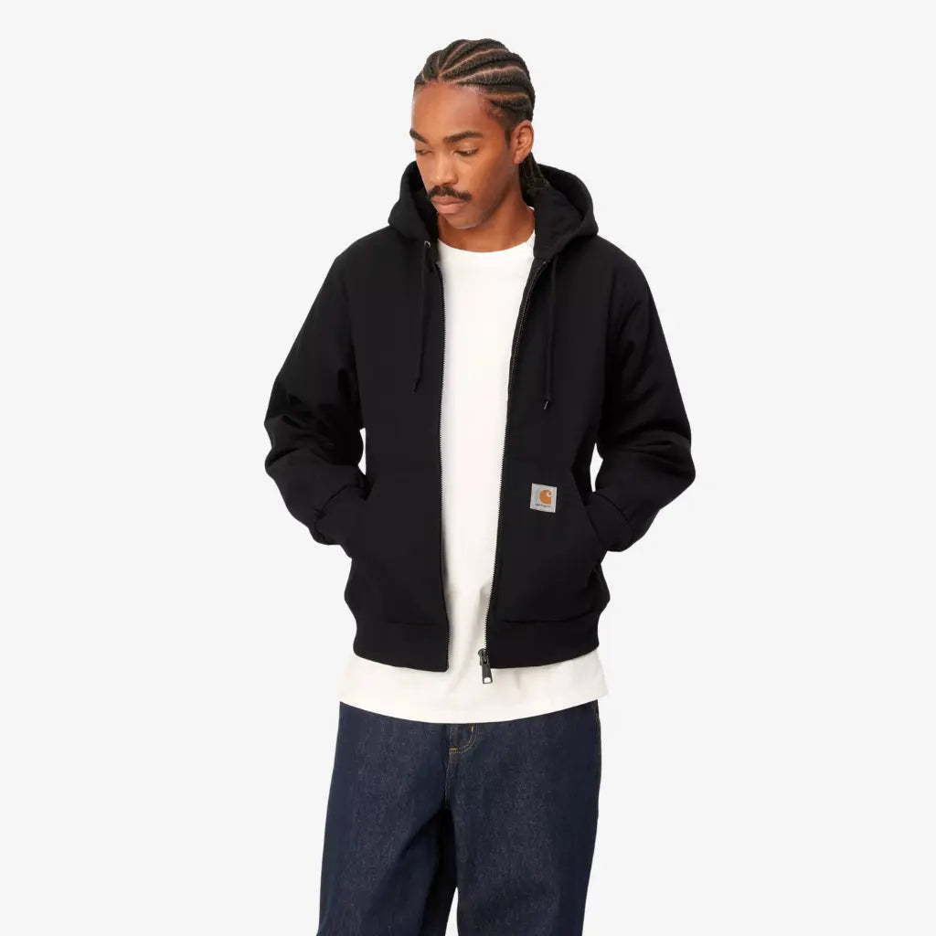 Veste Active Winter Black Rigid Carhartt WIP portée ouverte sur un t-shirt blanc, vue de face