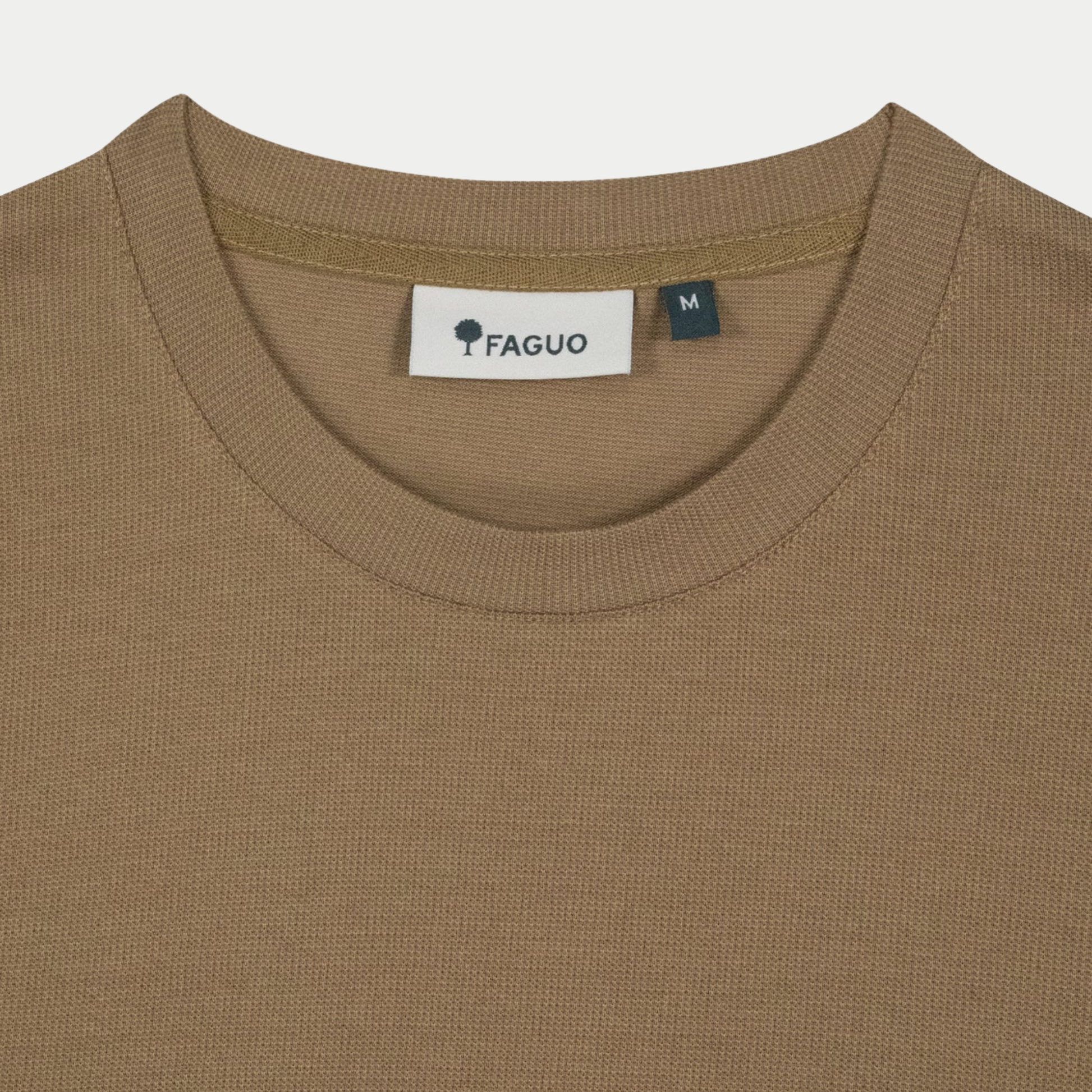 Gros plan du col rond côtelé et de l'étiquette FAGUO du t-shirt Bailly camel