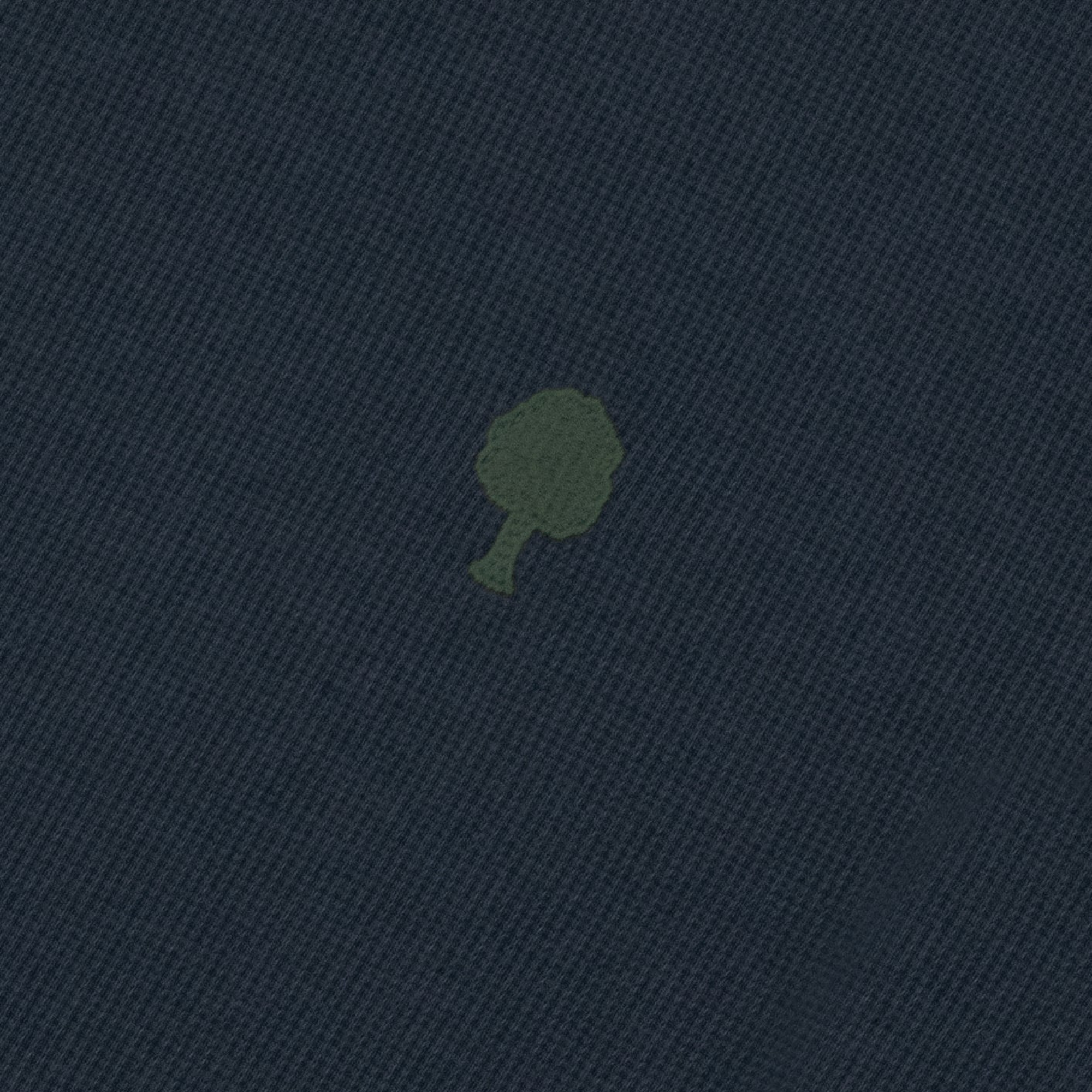 Détail de la maille piquée gaufrée bleu marine et de l'arbre brodé vert olive du t-shirt Bailly Faguo