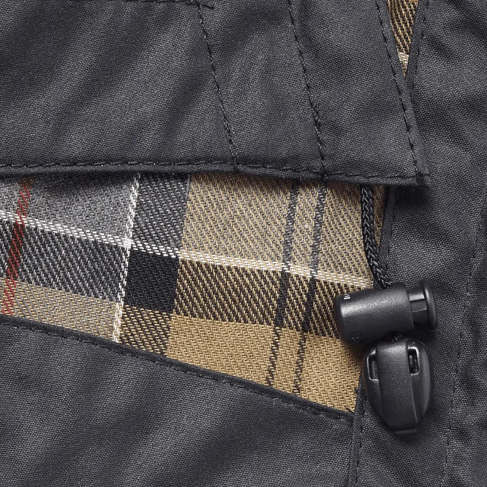 Détail de la capuche Barbour Wax navy : doublure tartan, surpiqûres du coton ciré et stoppeur de cordon