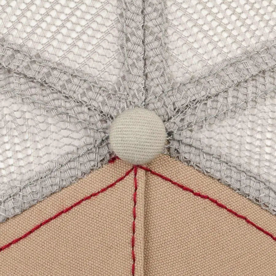Détail de la casquette Bear Stetson : bouton de calotte recouvert, filet gris et surpiqûre rouge sur la toile beige