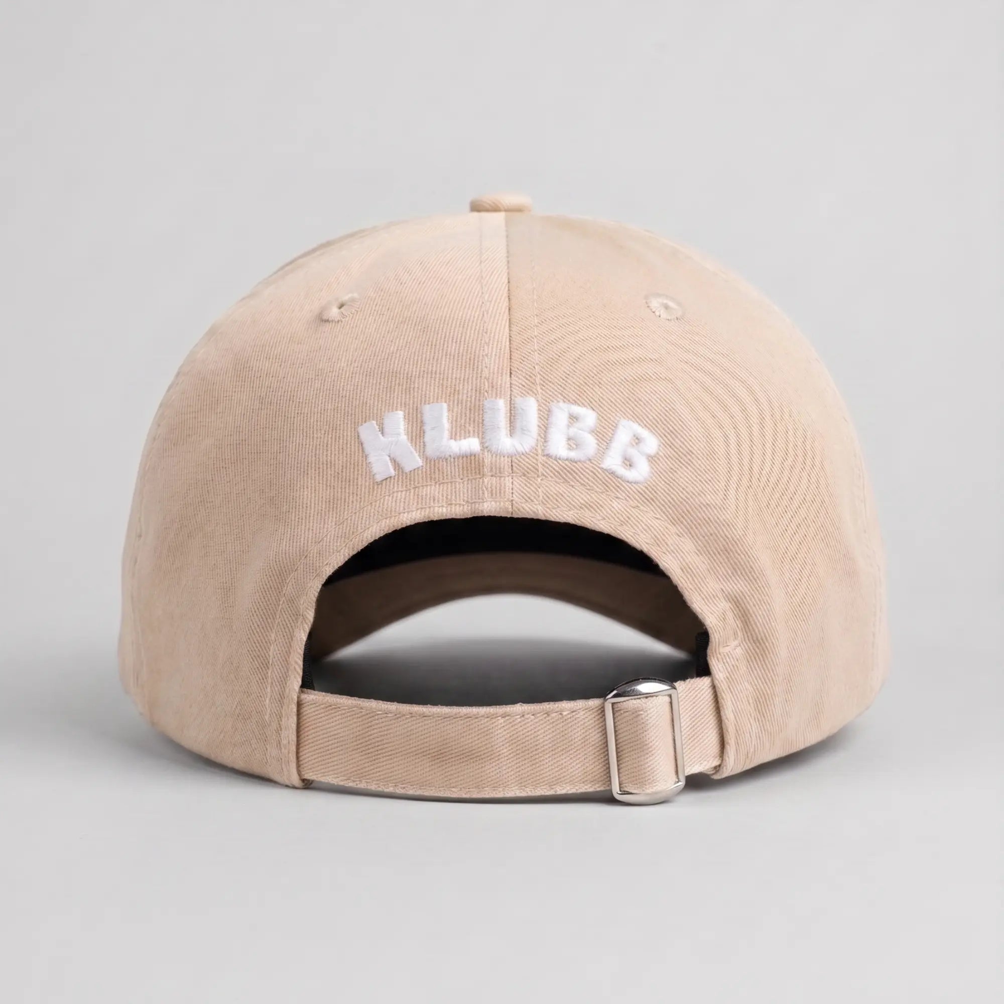 Dos de la casquette Klubb beige sable : logo KLUBB blanc brodé en arc, sangle beige et boucle métal argentée