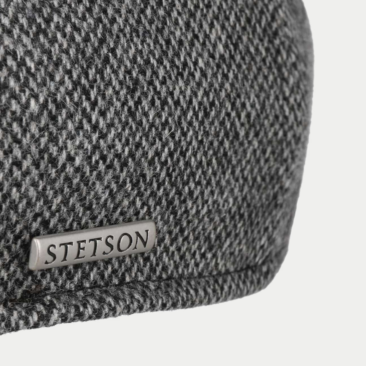 Macro du tissu de laine à chevrons gris anthracite chiné et emblème métal Stetson