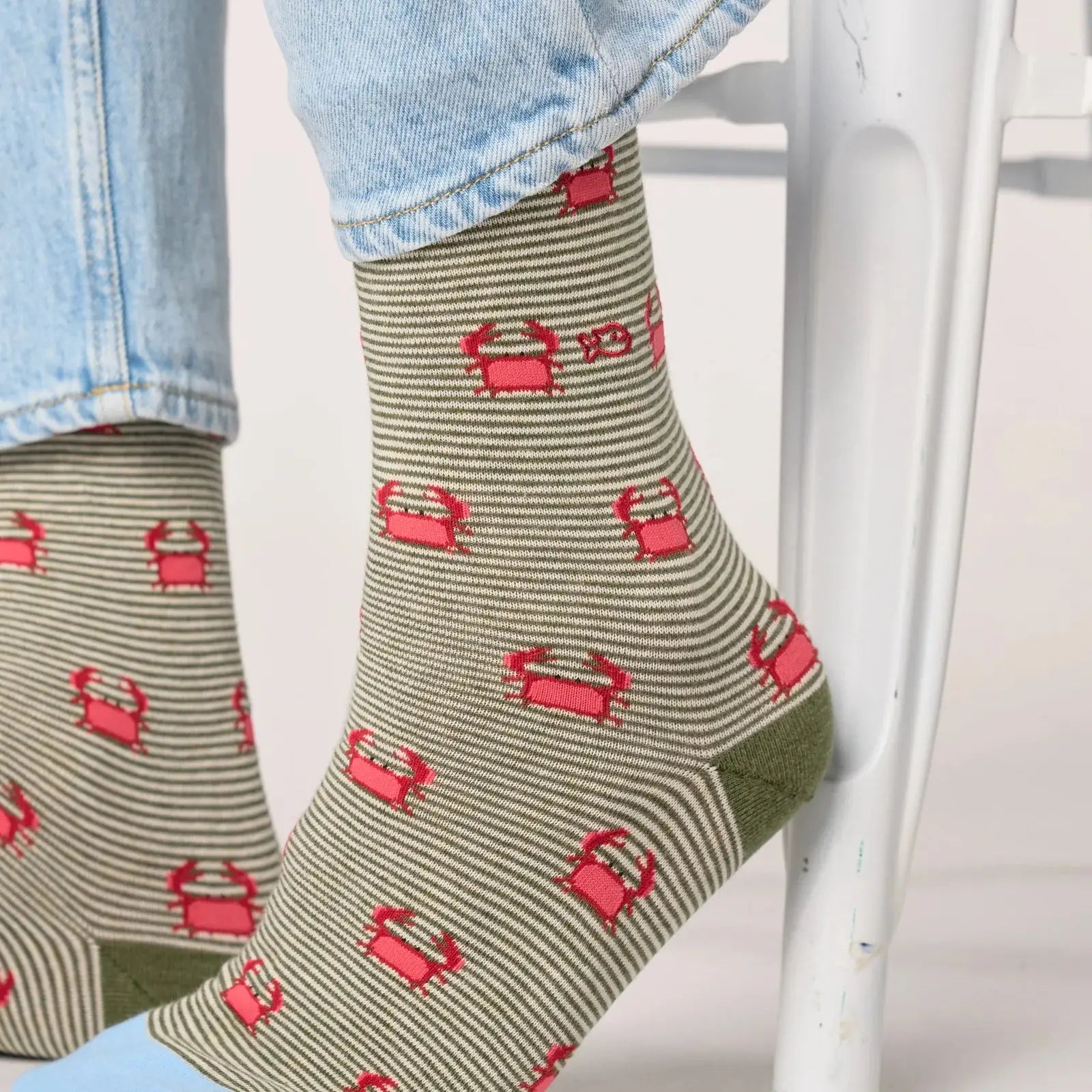 Détail des chaussettes Billybelt à motif crabes portées, rayures kaki