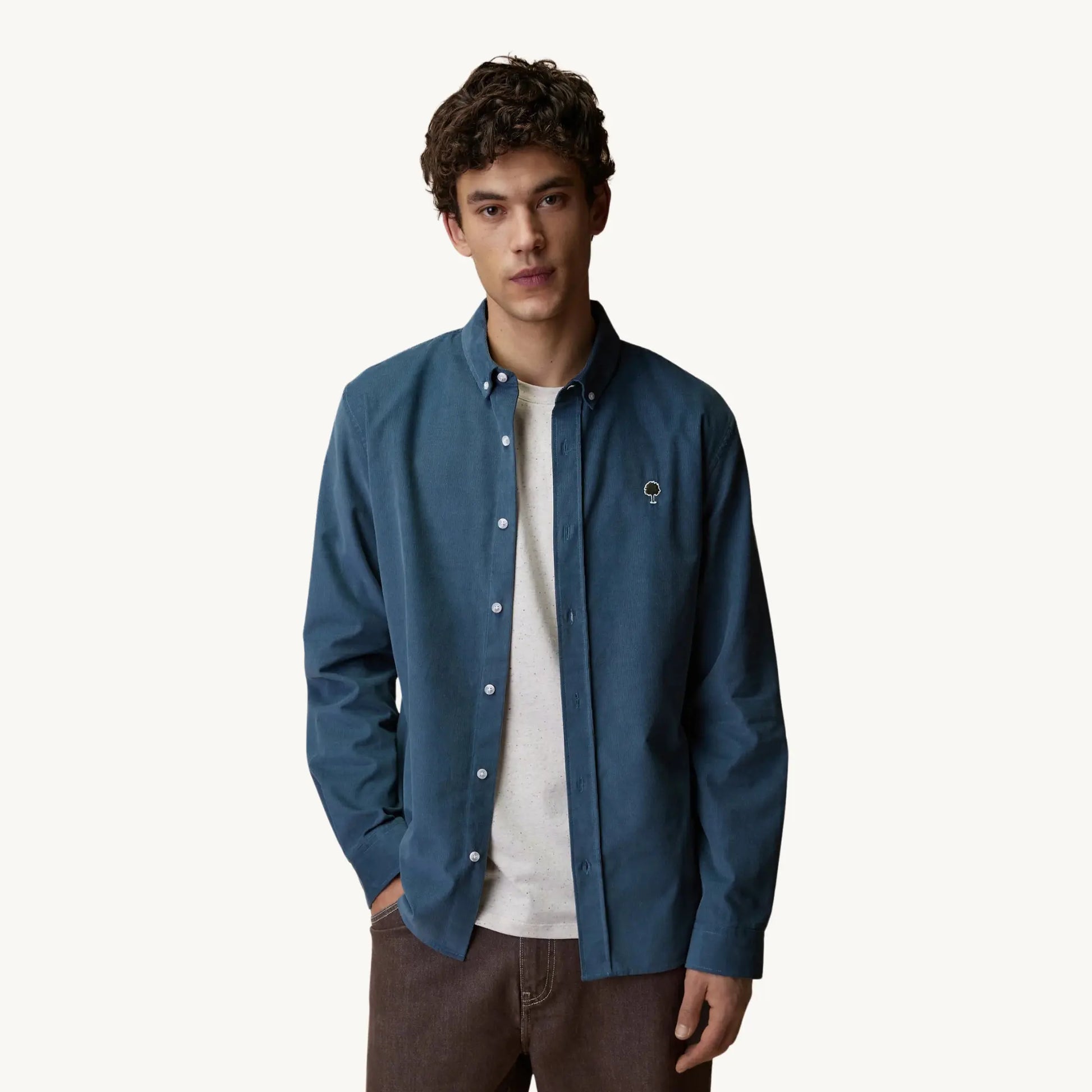 Chemise Ivoy Velours Bleu Faguo portée ouverte sur un t-shirt écru, vue de face, coupe droite