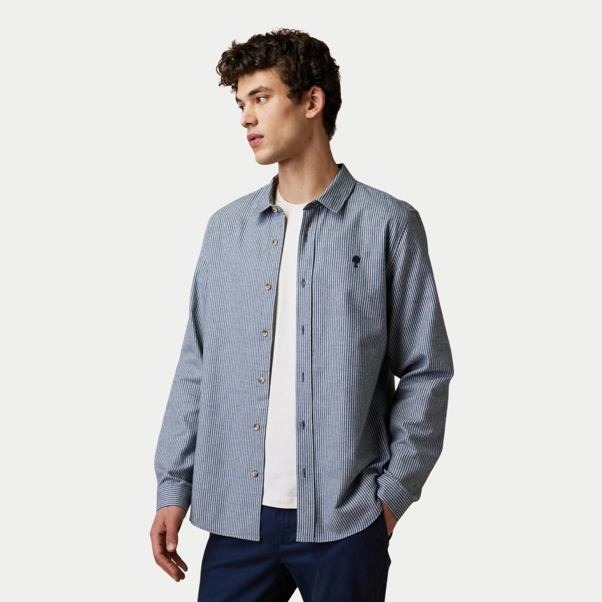 Chemise Iraty Faguo rayée écru et marine portée ouverte sur un t-shirt blanc, vue de trois quarts