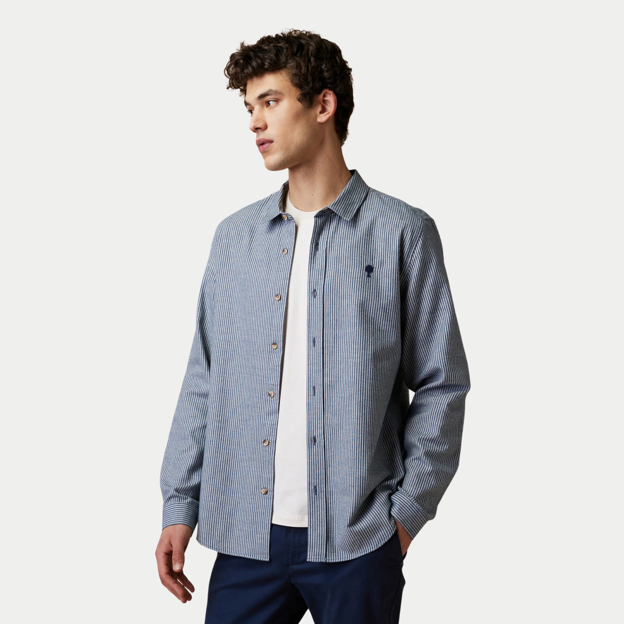 Chemise Iraty Faguo rayée écru et marine portée ouverte sur un t-shirt blanc, vue de trois quarts