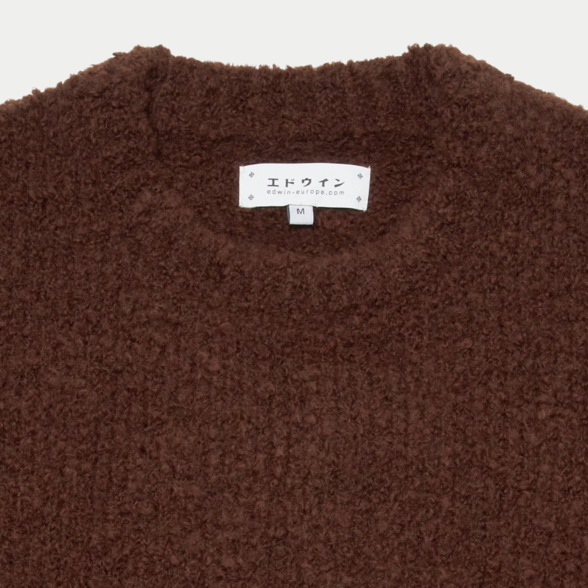 Détail du col rond du pull Dun Edwin marron et de son étiquette de marque intérieure