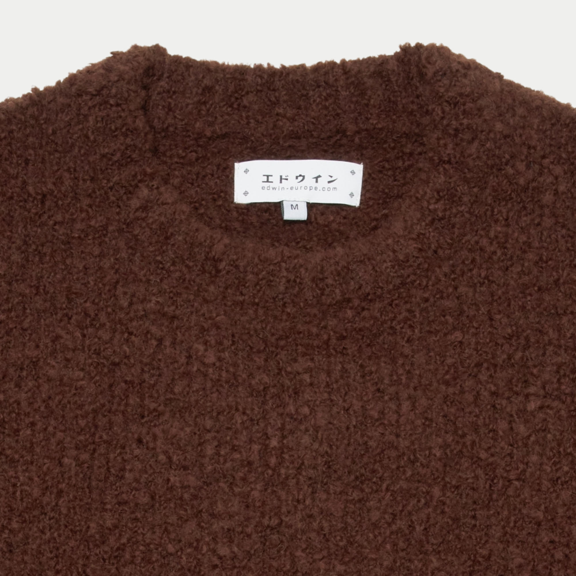 Détail du col rond du pull Dun Edwin marron et de son étiquette de marque intérieure