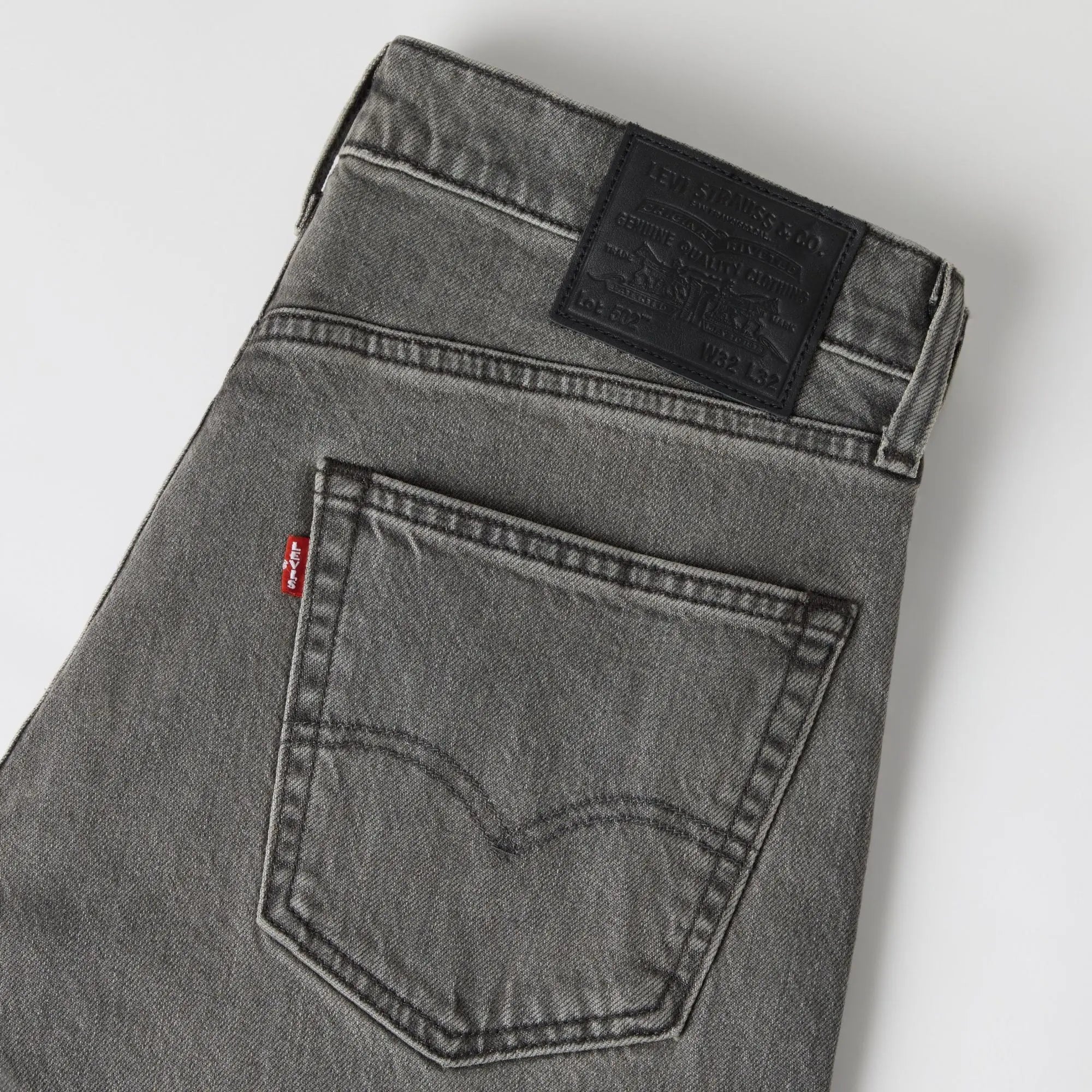 Détail du jean Levi's 502 Taper Granite Shadow : poche arrière arquée, tab rouge et patch cuir Lot 502