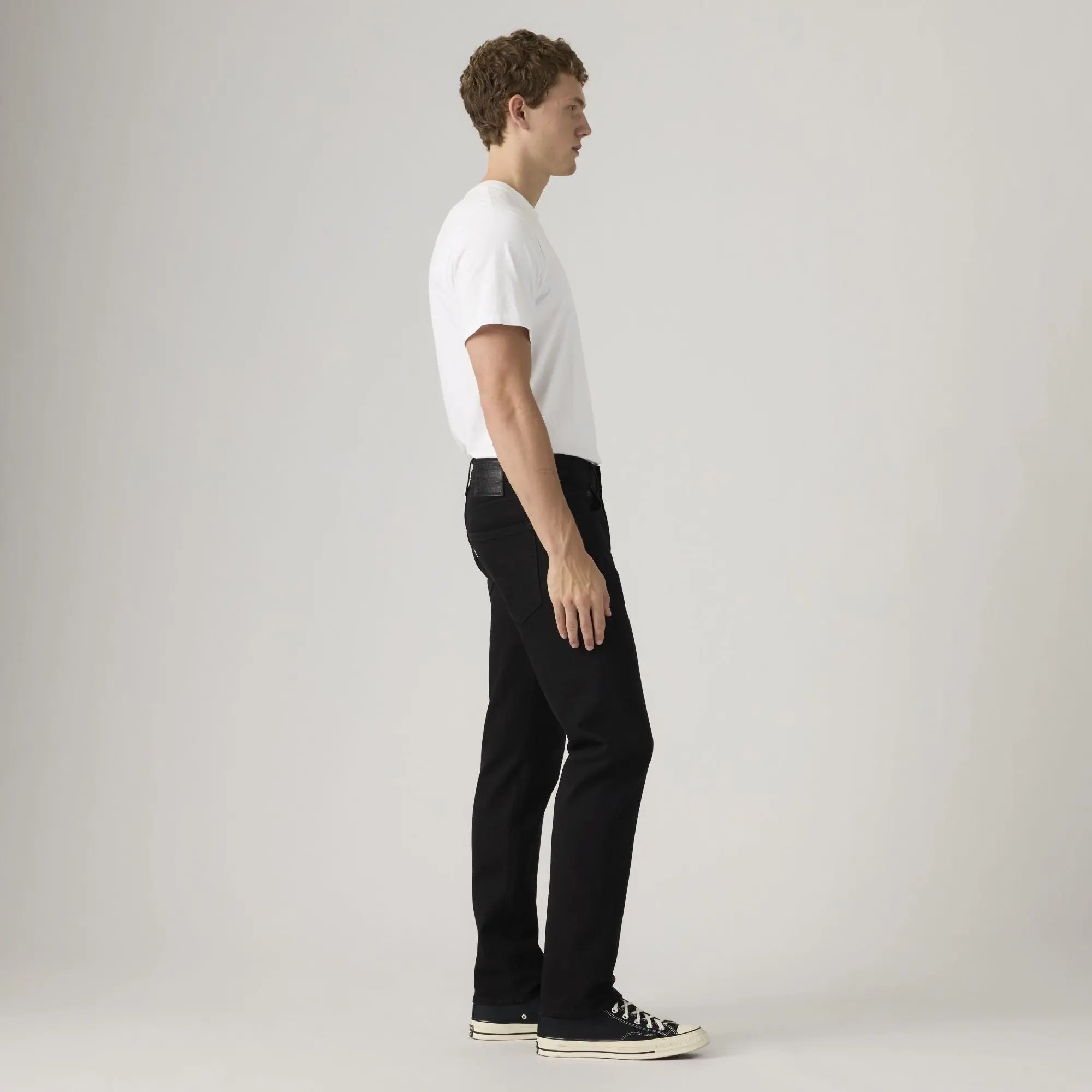 Jean Levi's 502 Taper Sta-Dark Black vu de profil, tombant fuselé jusqu'aux baskets basses