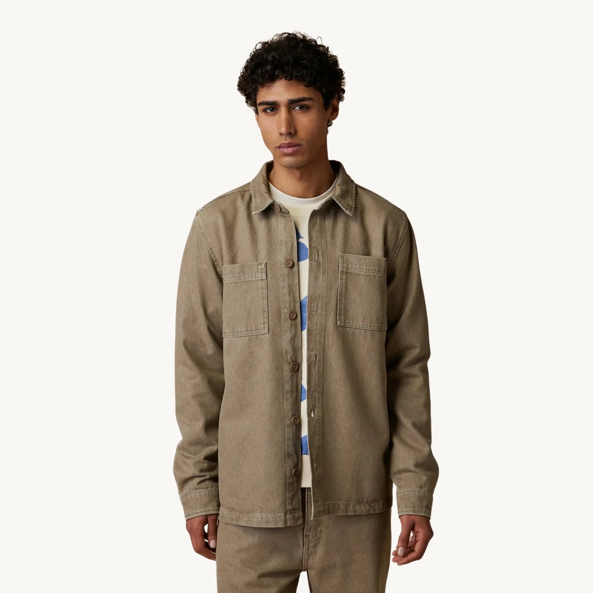 Surchemise Clemont Sable Faguo portée ouverte sur un sweat écru, de face : coupe ample en denim beige sable