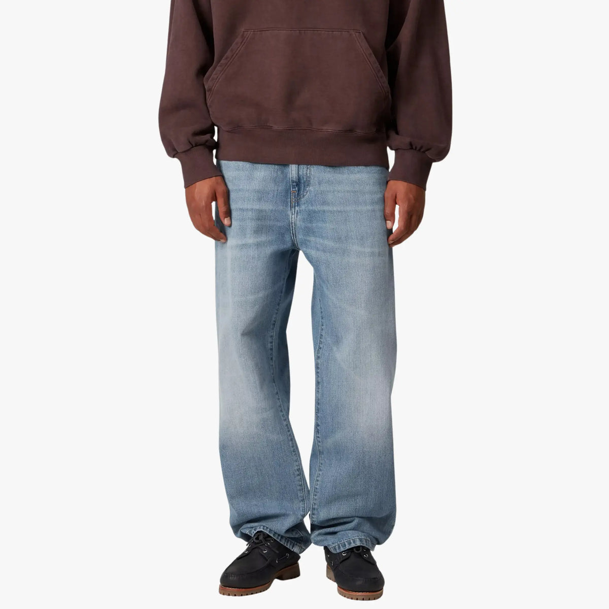 Aaron Pant Blue Burst Wash porté de face, jambe droite et ample au délavage clair, bas cassant sur la chaussure