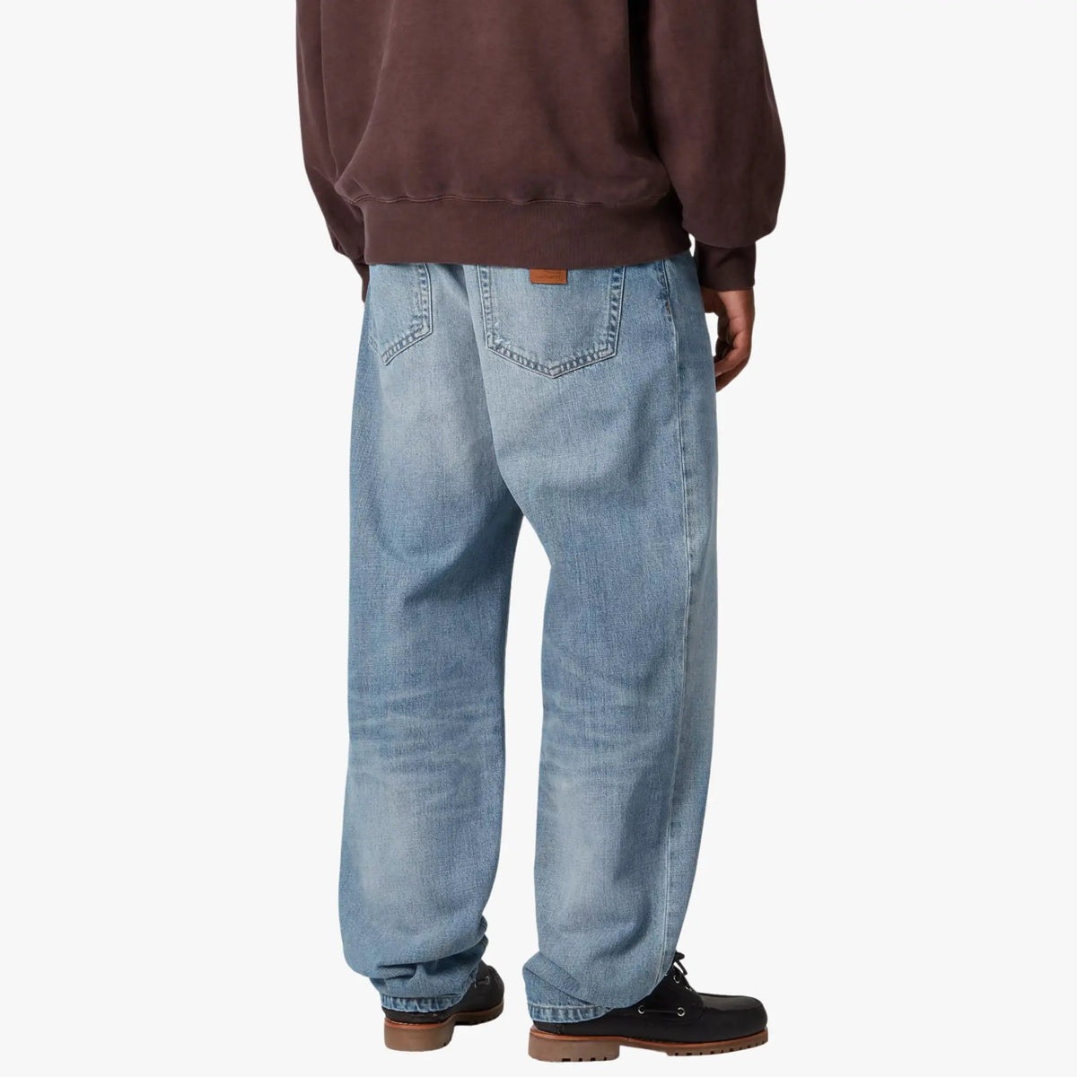 Aaron Pant Blue Burst Wash porté de dos, poches plaquées et patch cuir, tombant droit jusqu'au talon