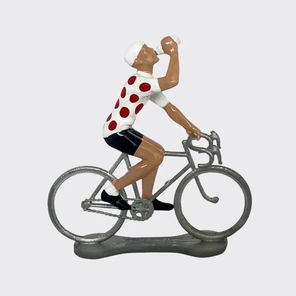 Figurine de cycliste en métal peint buvant au bidon, maillot blanc à pois rouges, vue de profil