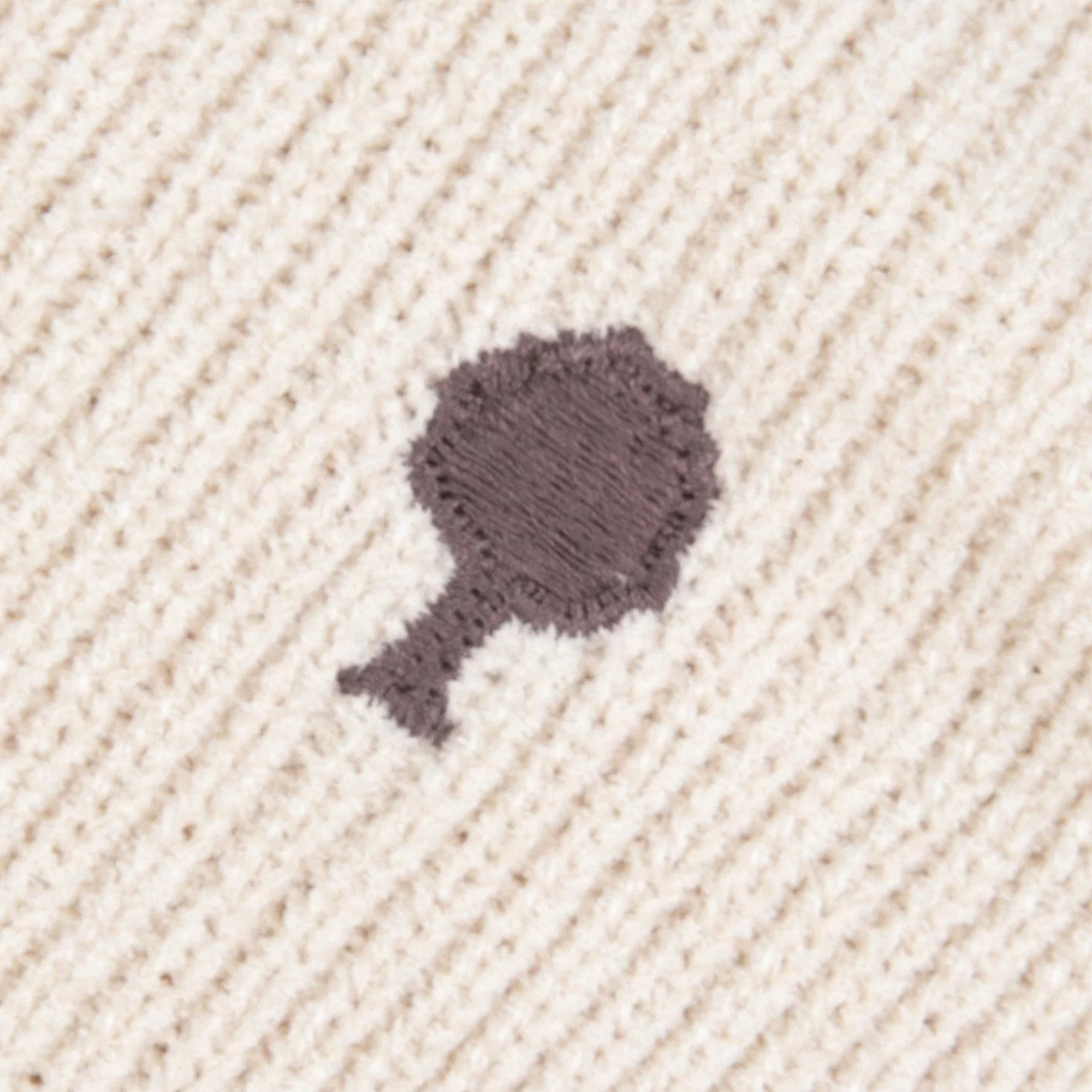 Gros plan sur la maille côte 1x1 écrue et la broderie arbre prune du pull Aulnay Faguo