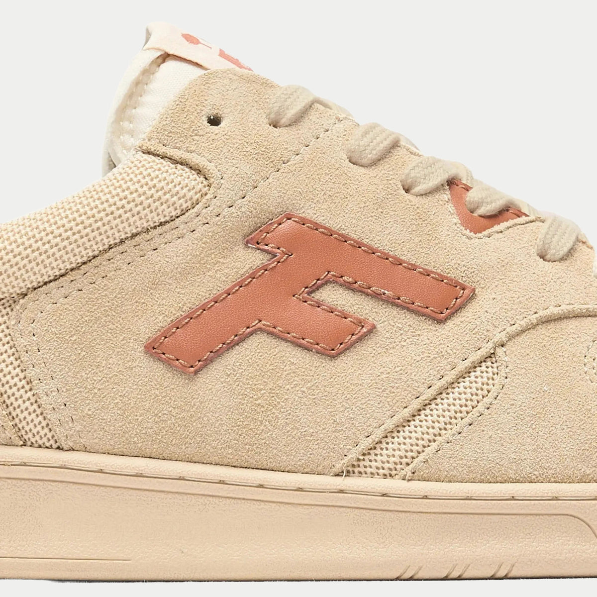 Baskets Palmer beige et rouille Faguo - gros plan sur le logo F en cuir rouille cousu sur le daim beige