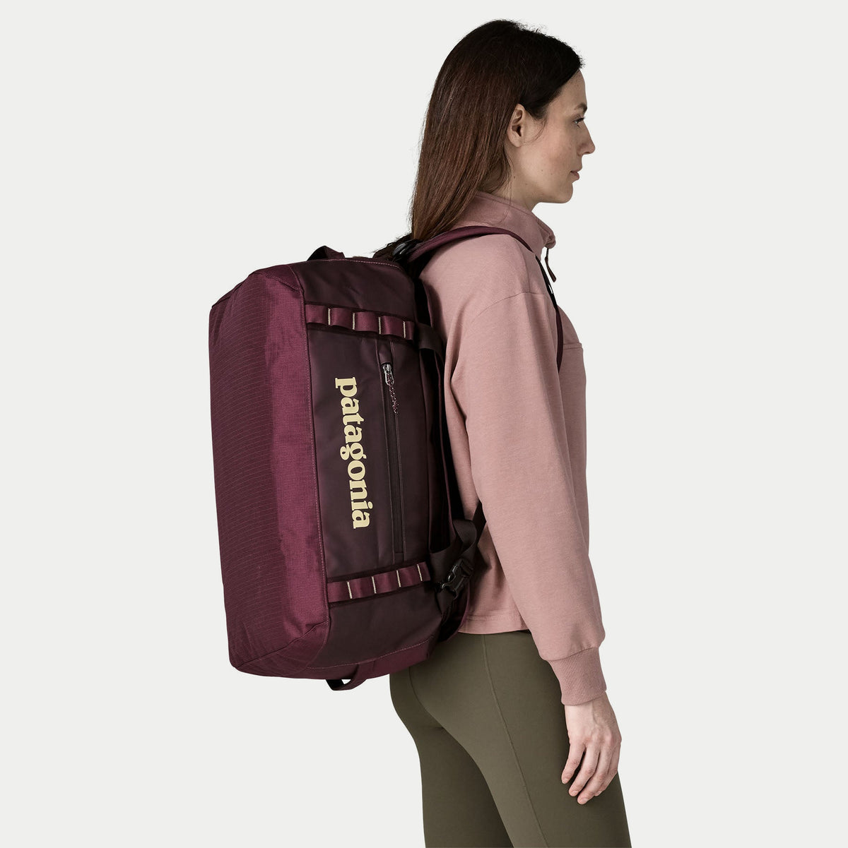 Duffel Black Hole 40L Berry Fig porté en sac à dos, bretelles rembourrées déployées, vue de profil