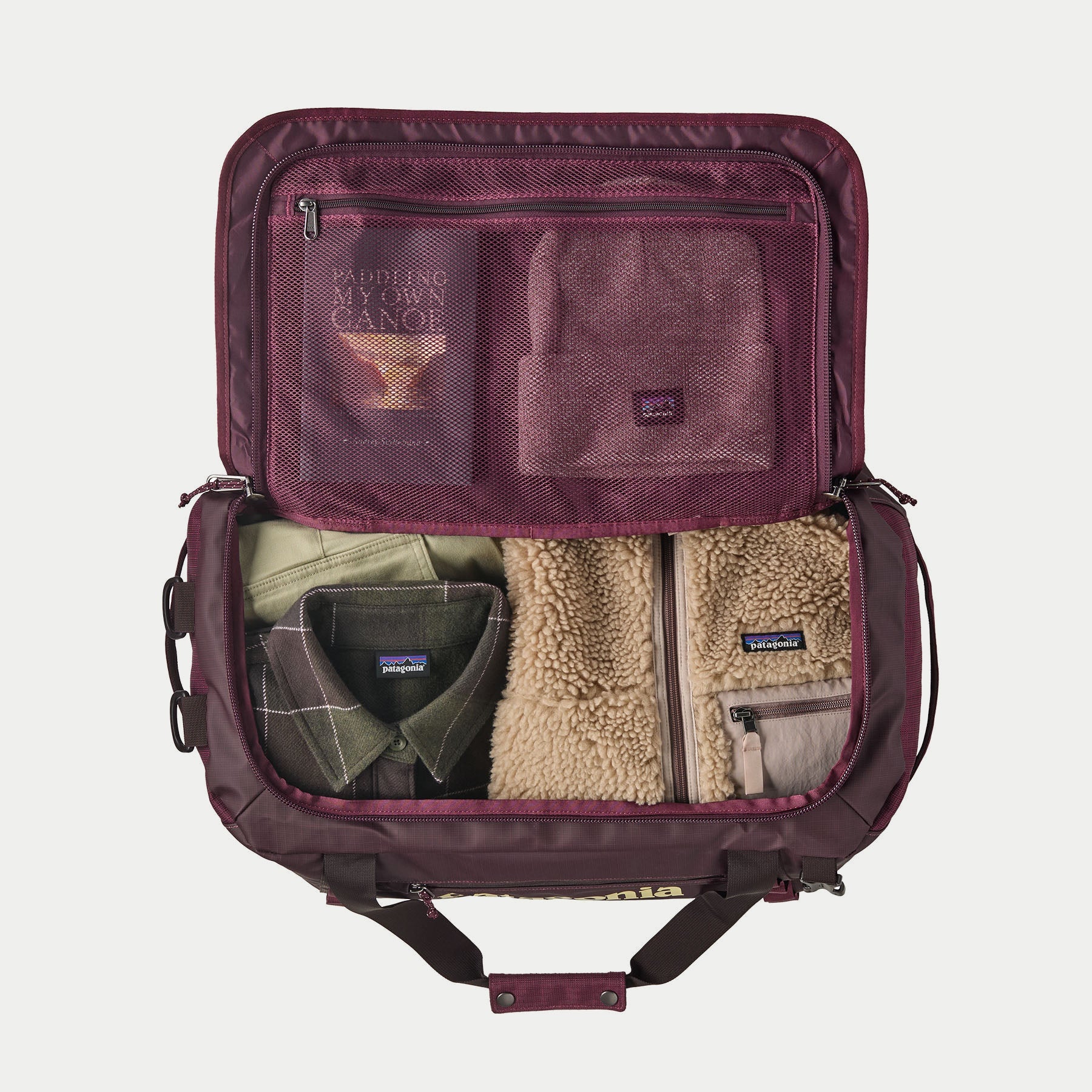 Duffel Patagonia Black Hole 40L Berry Fig ouvert à plat, poches filet zippées du rabat et compartiment principal garni