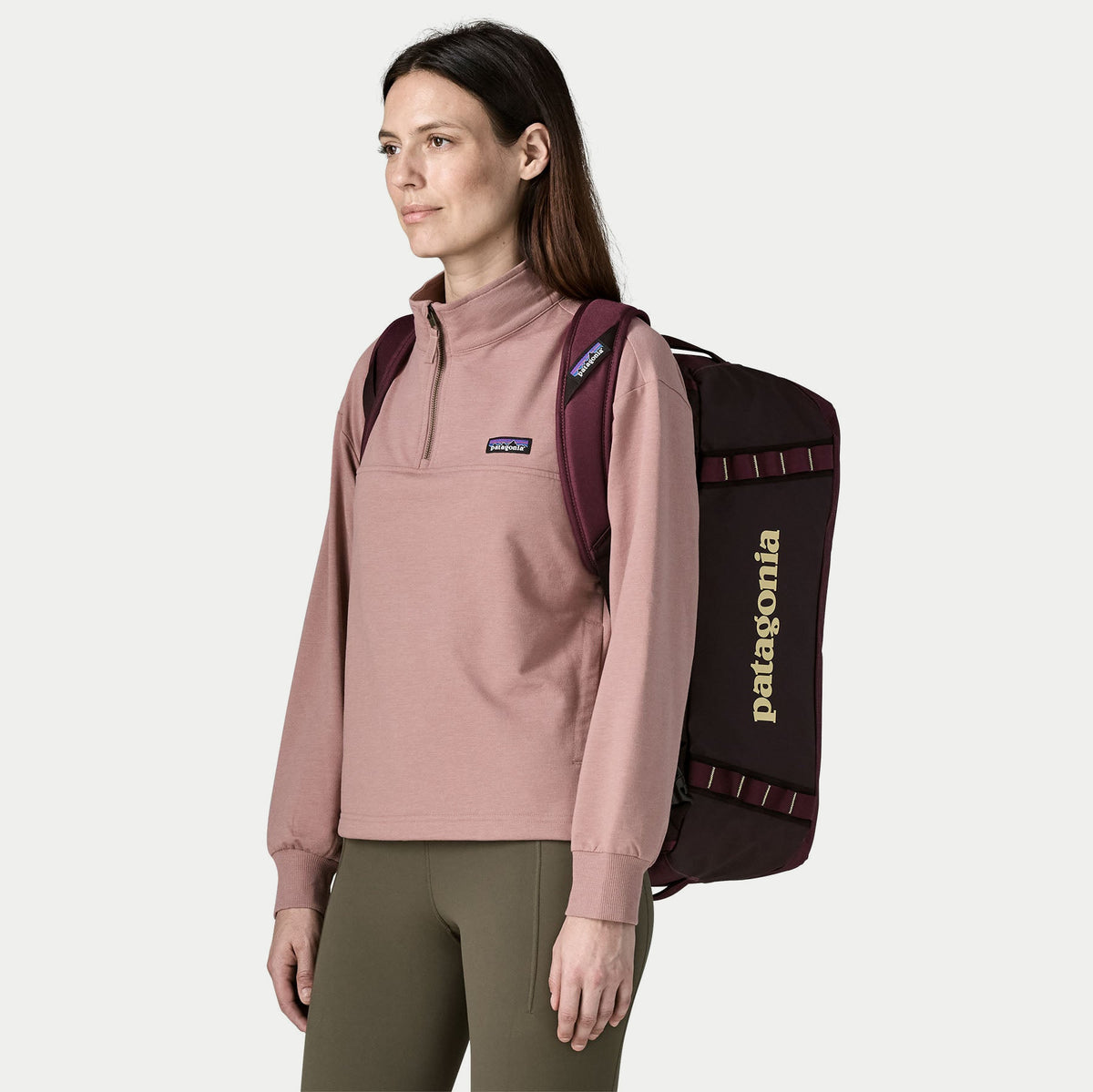 Duffel Black Hole 40L Berry Fig porté à dos de trois quarts face, sangles d'épaule réglables