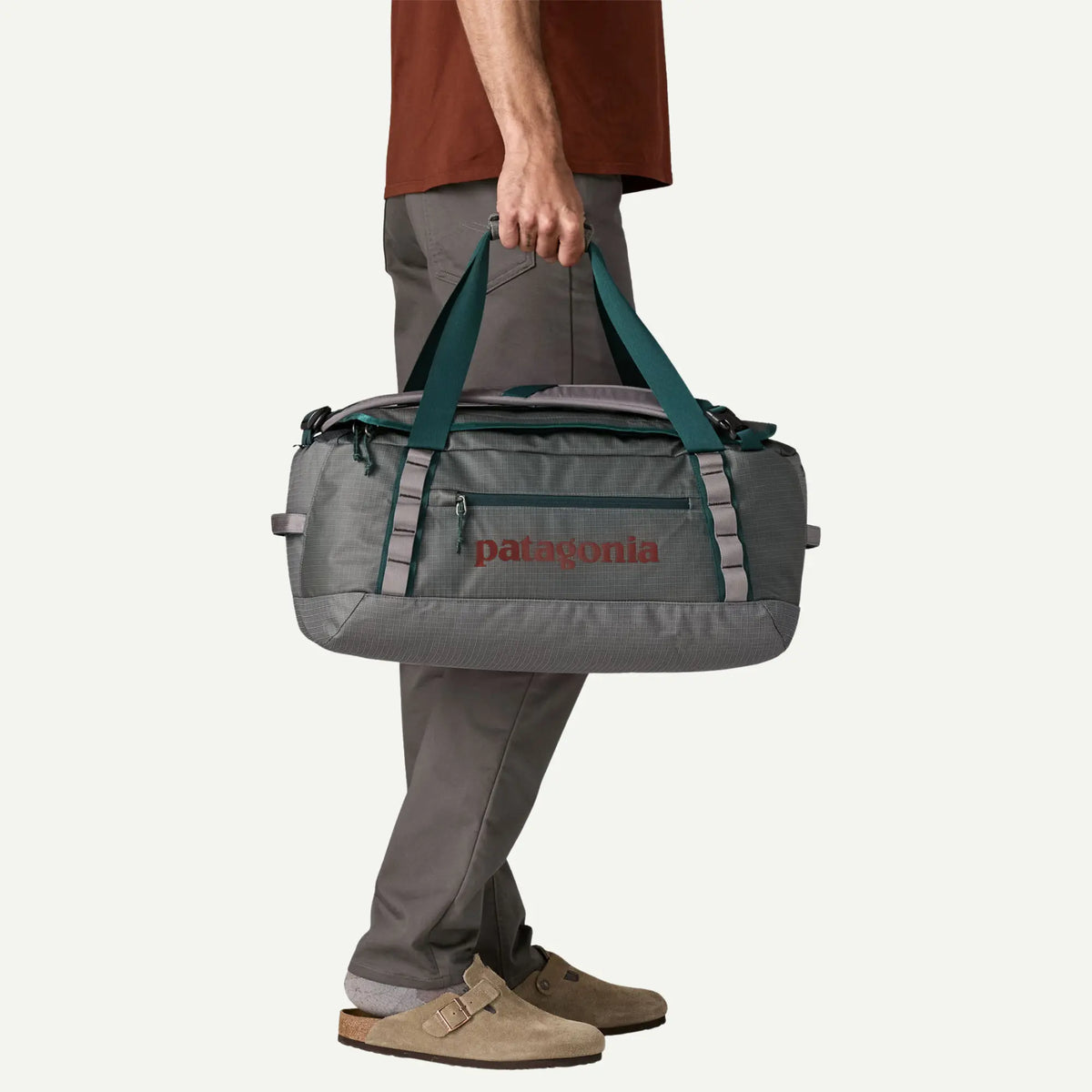 Black Hole Duffel 40L Noble Grey porté à la main par ses poignées vert canard
