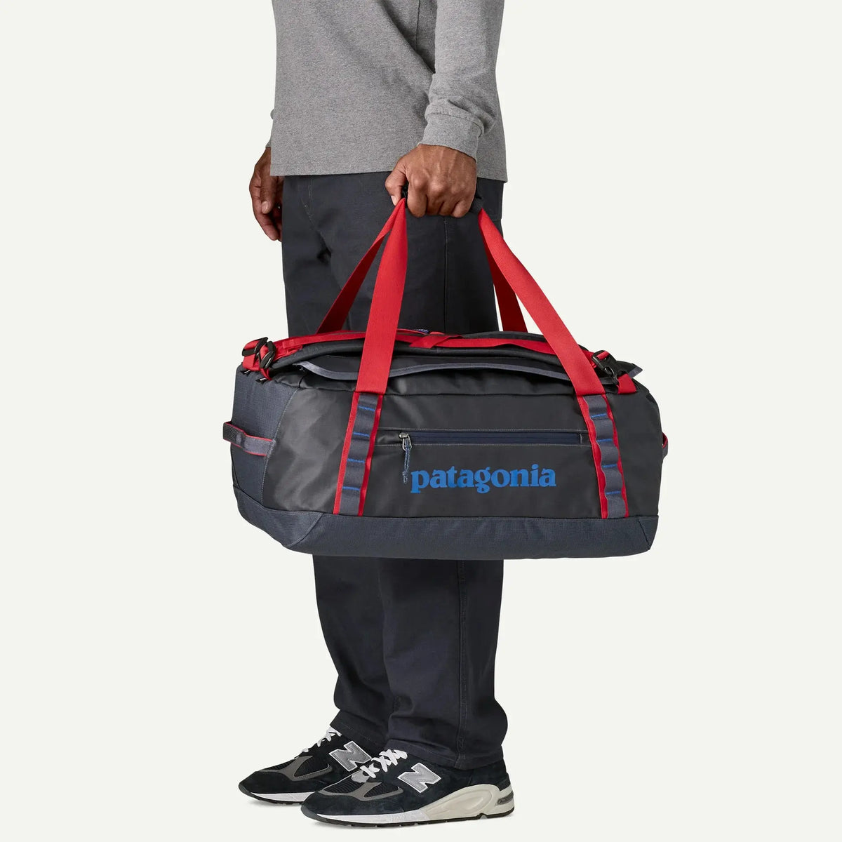 Black Hole Duffel 40L Smolder Blue porté à la main, longues poignées rouges et poche avant zippée