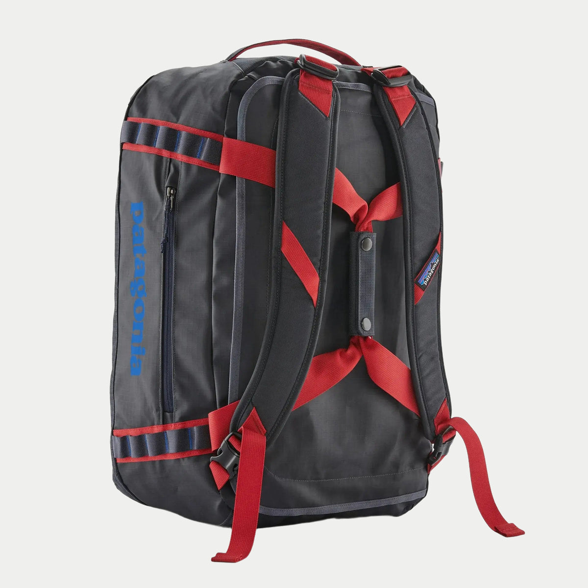 Dos du Black Hole Duffel 40L Smolder Blue, harnais rembourré et sangles Amanita Red