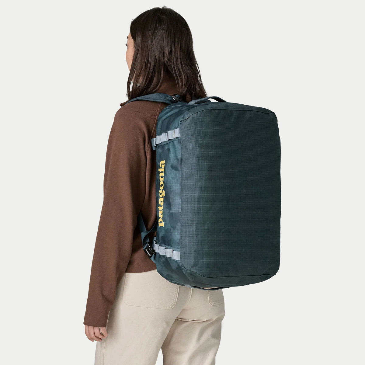 Black Hole Duffel 40L Patagonia bleu ardoise porté sur le dos, logo vertical et sangles gris clair