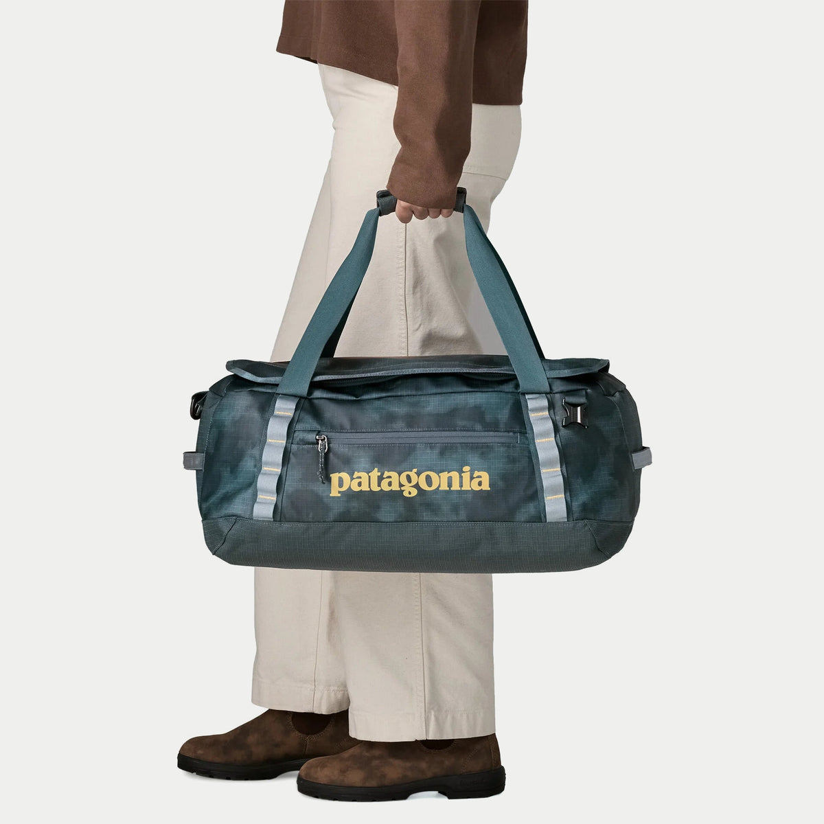 Black Hole Duffel 40L Patagonia porté à la main par les poignées jumelées, poche zippée frontale