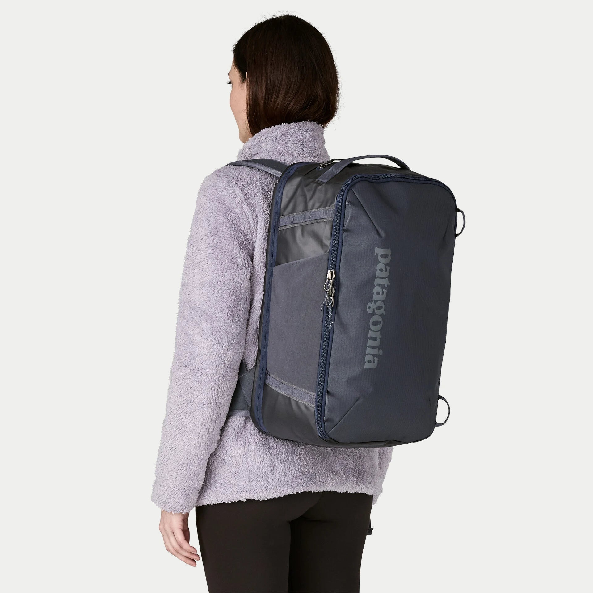 Sac Black Hole Mini MLC 30L Smolder Blue Patagonia porté en sac à dos, panneau avant et poche zippée
