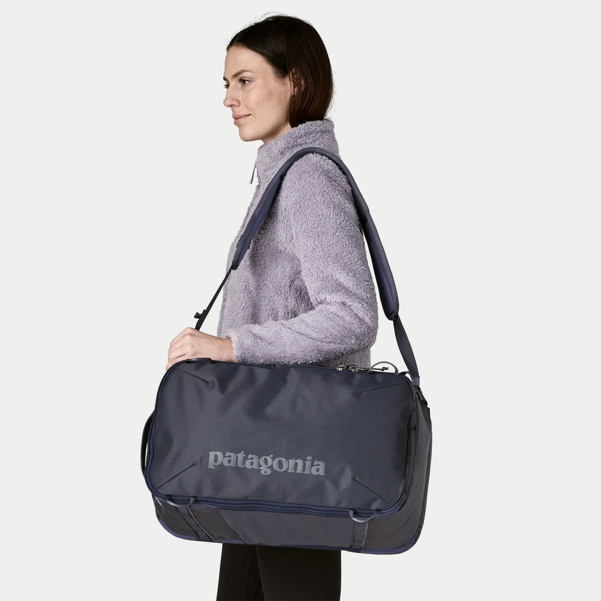Sac Black Hole Mini MLC 30L Smolder Blue Patagonia porté en bandoulière, face logo et sangle réglable