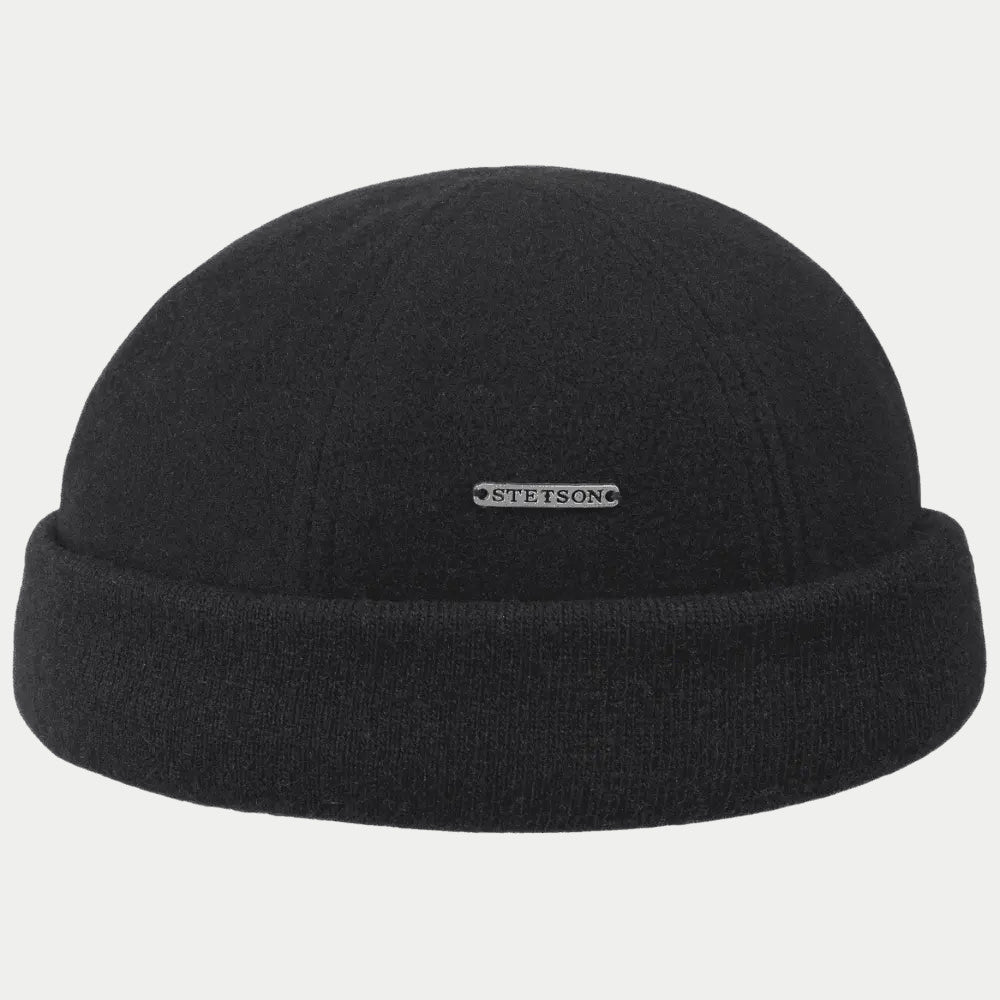Bonnet docker en laine noire de face, revers tricot et plaquette métal argentée