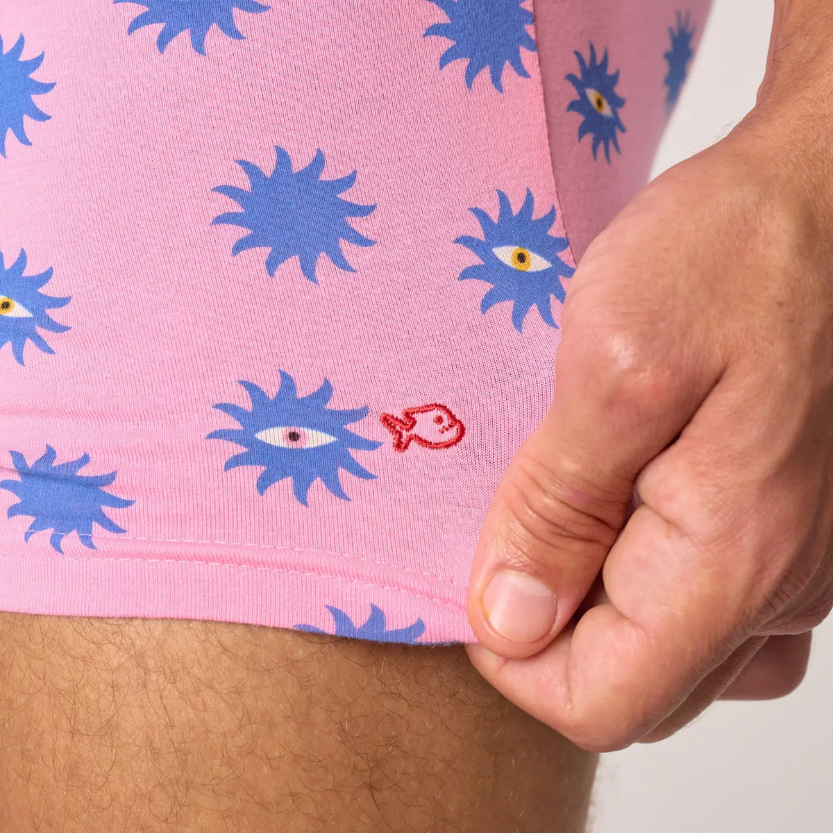 Détail du boxer Suneyes : poisson brodé rouge sur la jambe, soleils bleus à l'iris jaune et rouge