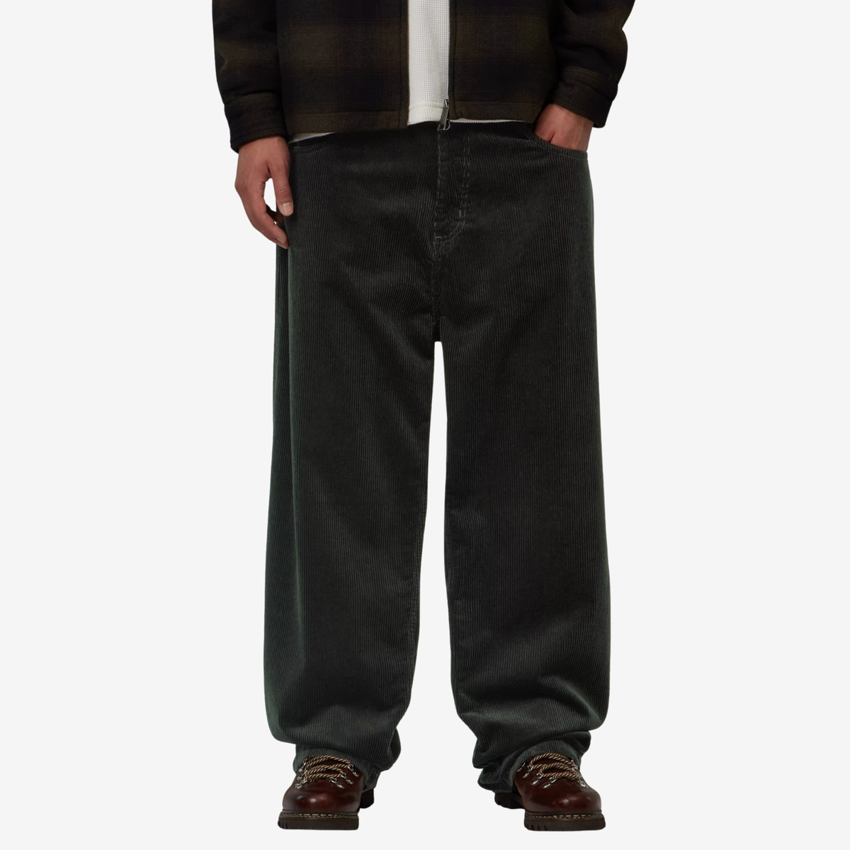 Brandon Pant Raven porté de face, jambe large et droite en velours côtelé vert sapin, sur des bottines de randonnée marron