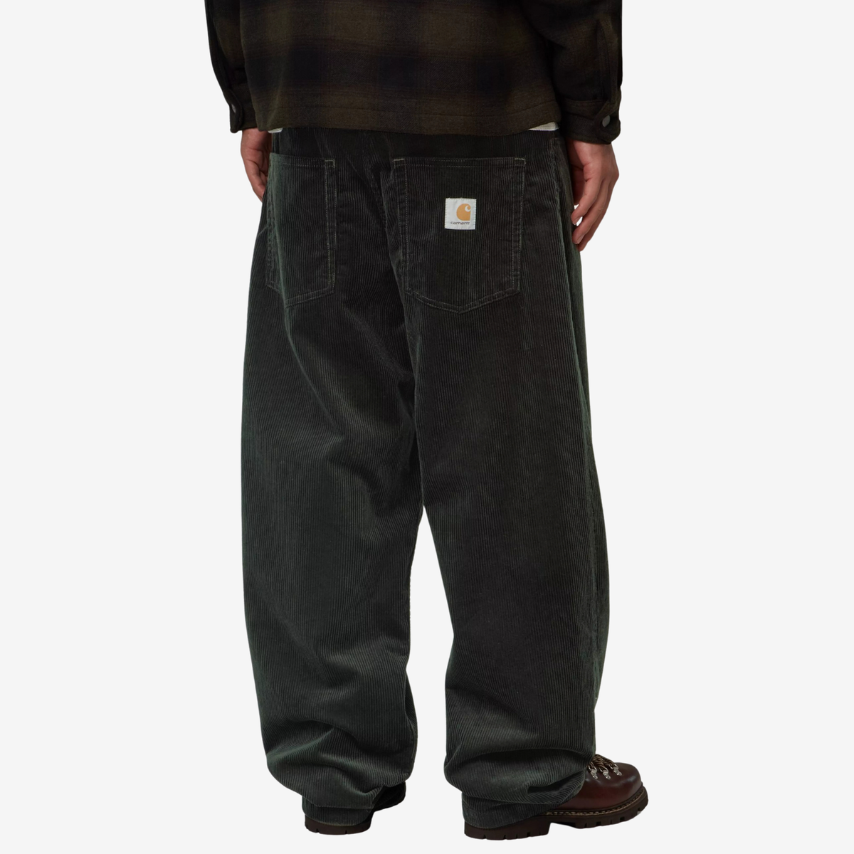 Brandon Pant Raven porté de dos avec une surchemise à carreaux : velours côtelé vert sapin et étiquette Carhartt WIP