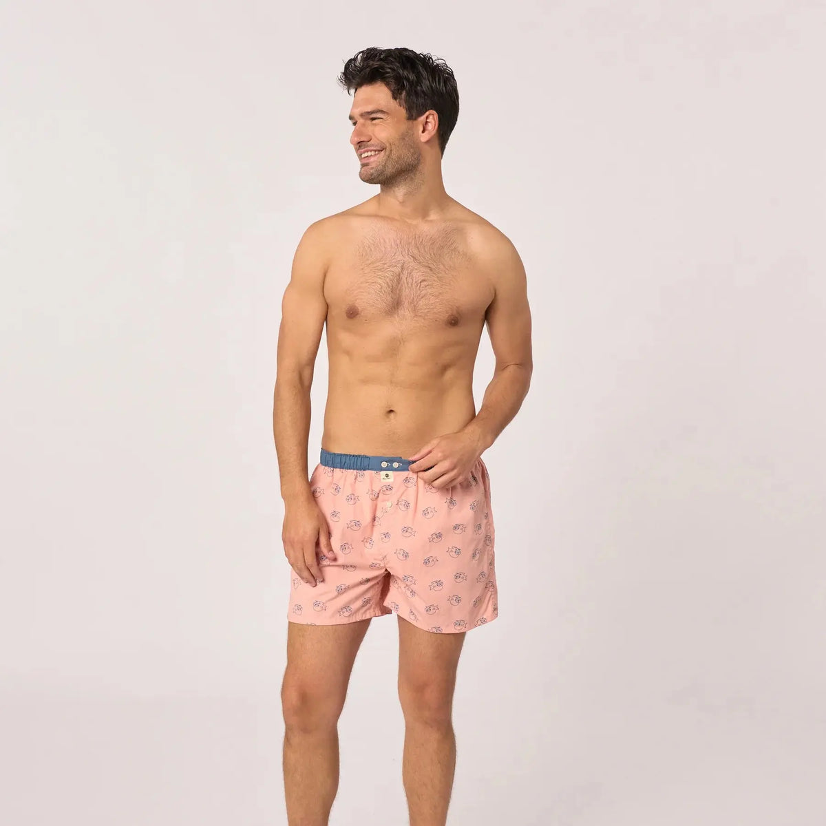 Caleçon Billychill vu en pied, fond rose poudré semé de poissons à lunettes, ceinture bleu ardoise