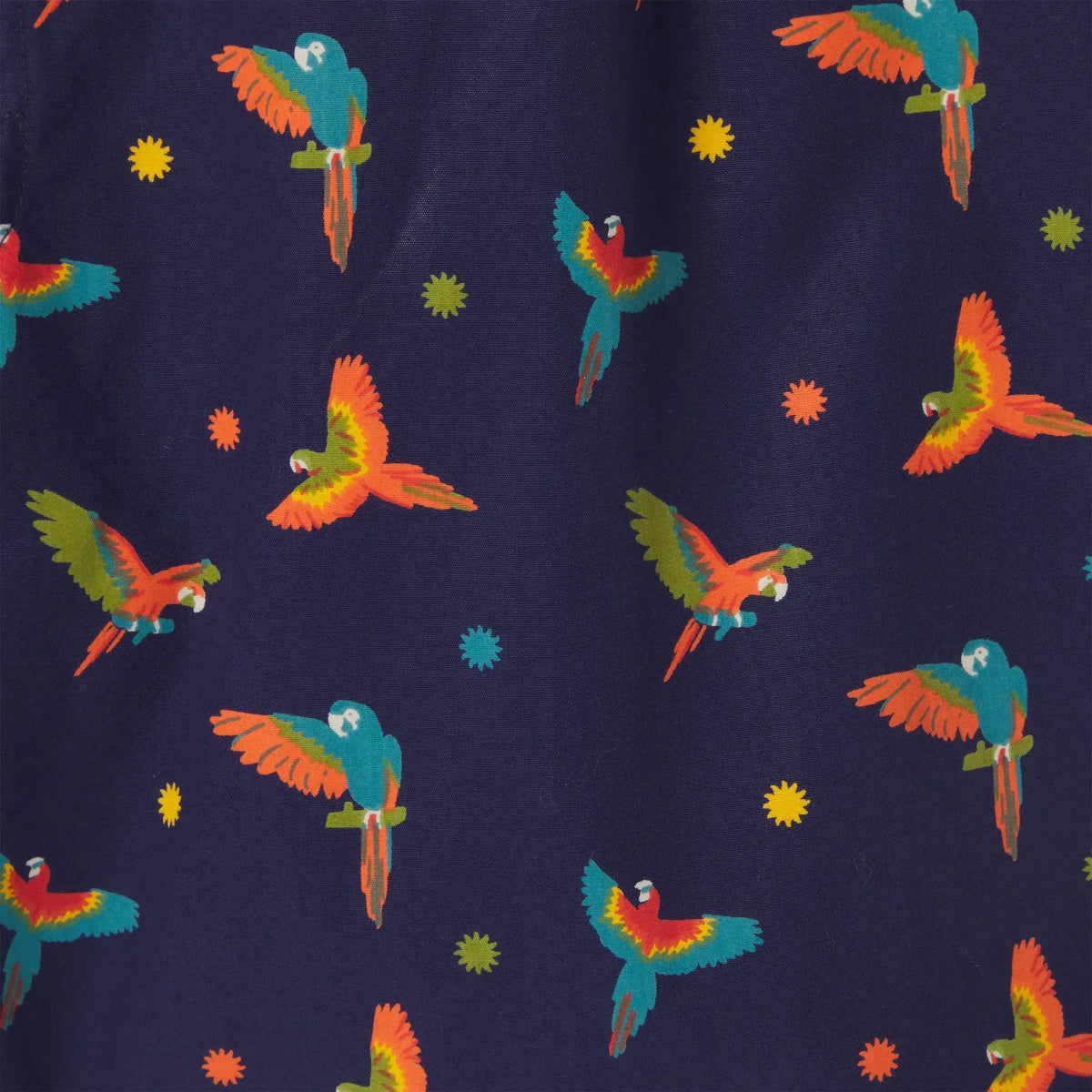 Macro de l'imprimé : aras aux ailes orange, vertes et turquoise et étoiles jaunes sur fond Bleu Marine