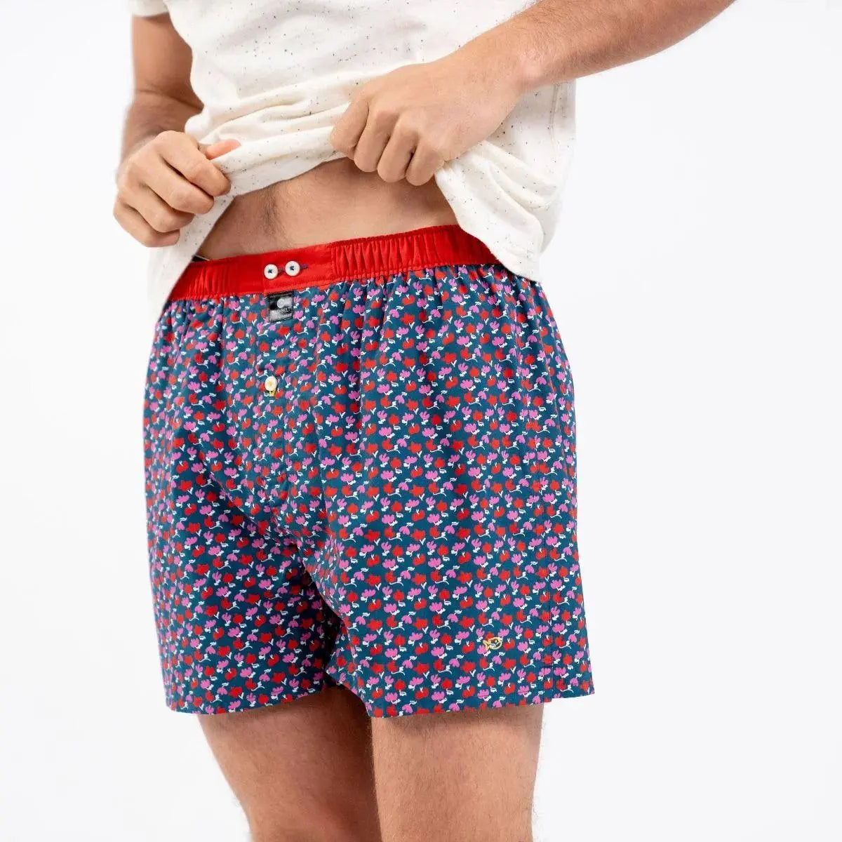 Caleçon Tululup porté, petites fleurs rouges et fuchsia à tiges blanches sur bleu canard, ceinture rouge