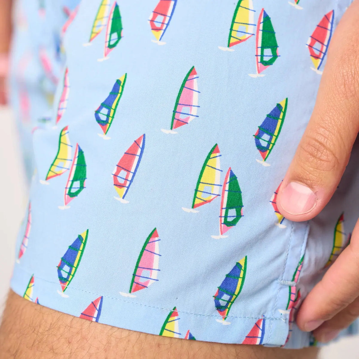 Détail du bas de jambe, voiles de windsurf colorées et wishbones bleus imprimés sur popeline bleu ciel