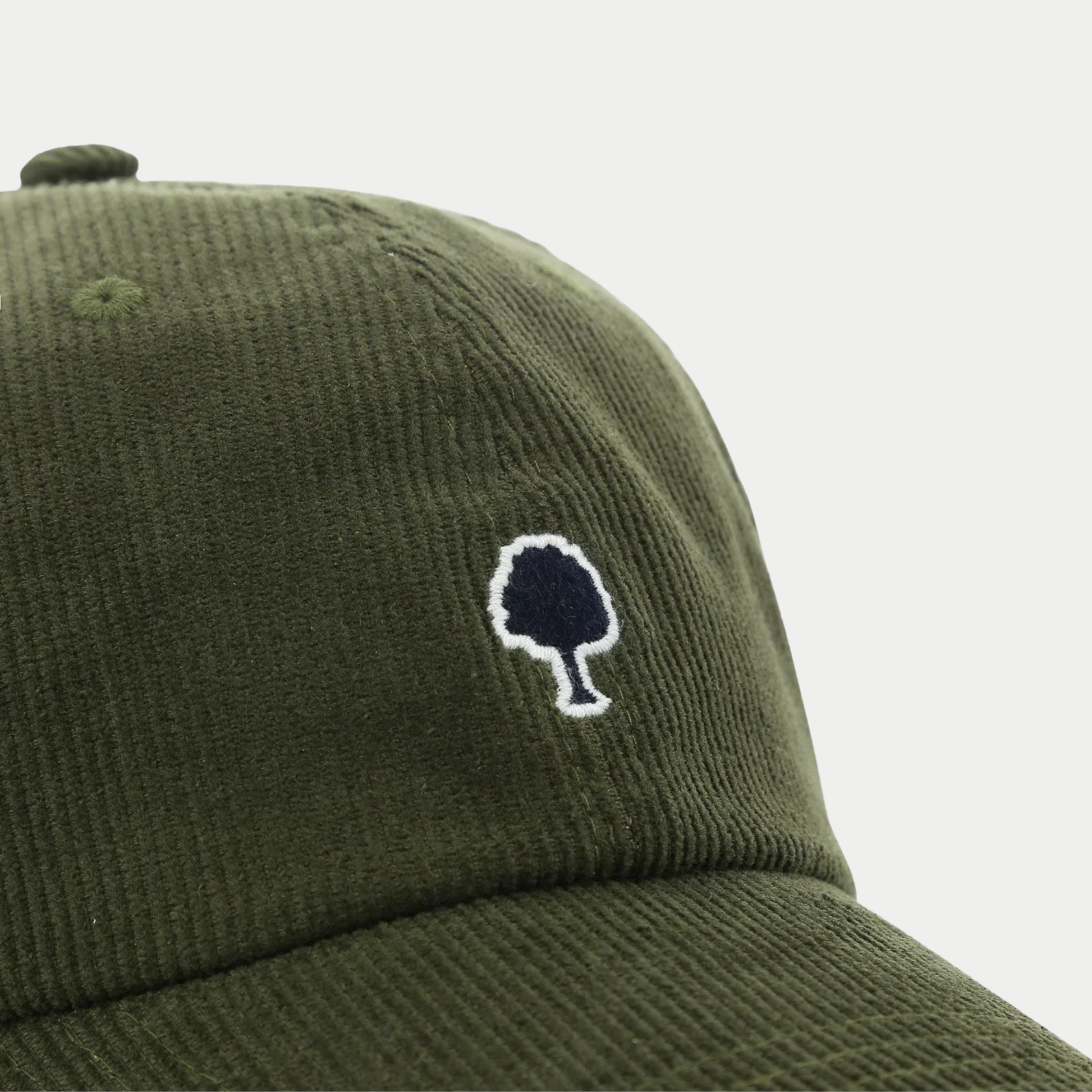 Macro du velours côtelé kaki de la casquette Faguo et de sa broderie arbre marine cernée de blanc