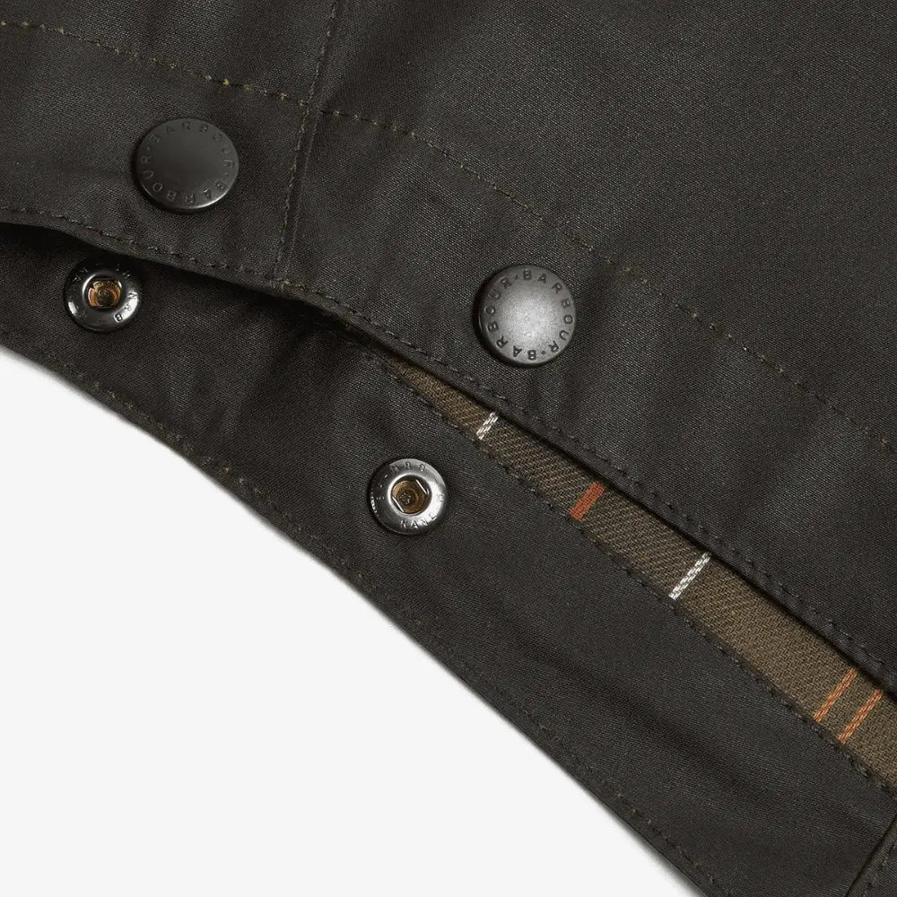 Gros plan des pressions gravées Barbour, doublure à carreaux olive et orange entrevue