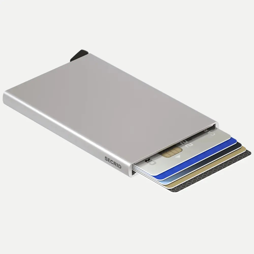 Boîtier aluminium argent posé à plat, cartes bancaires éjectées en éventail sur le côté