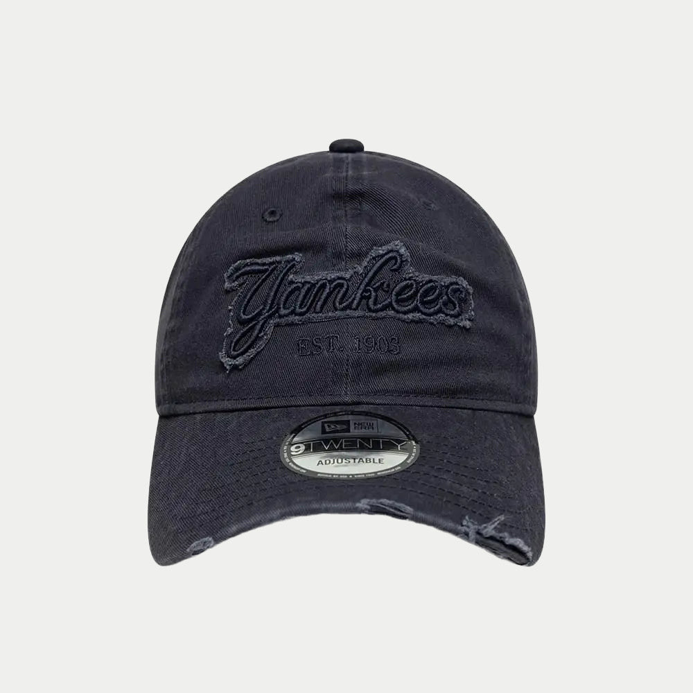 Vue de face : patch Yankees aux bords effilochés et mention EST. 1903 brodée sur la toile bleu marine
