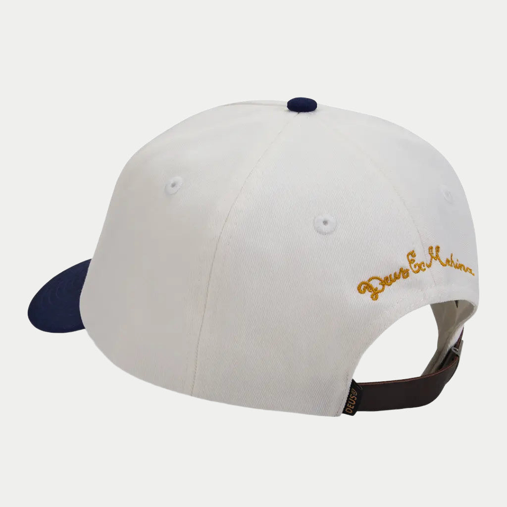Dos de la casquette Basto écrue Deus Ex Machina : script doré brodé, sangle réglable et visière marine