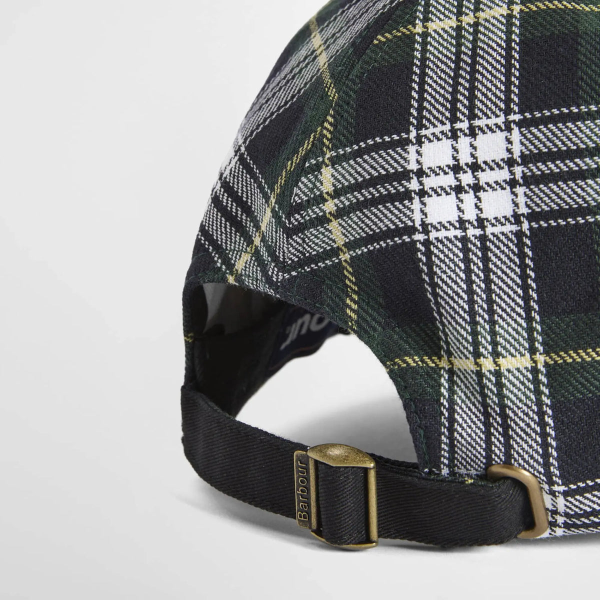 Gros plan de la boucle laiton gravée Barbour sur la sangle de réglage noire