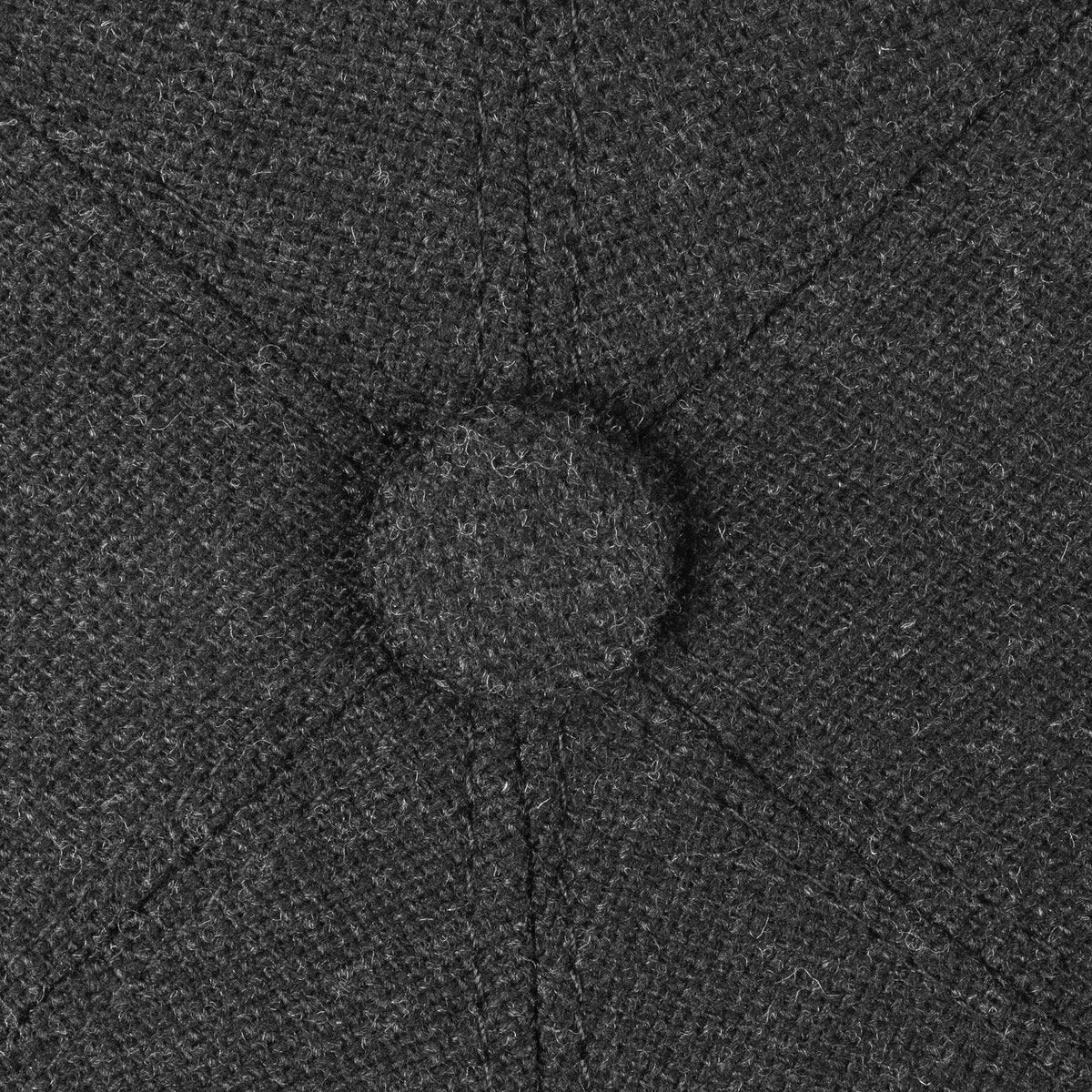 Macro du bouton recouvert et des coutures qui se rejoignent au sommet du lainage