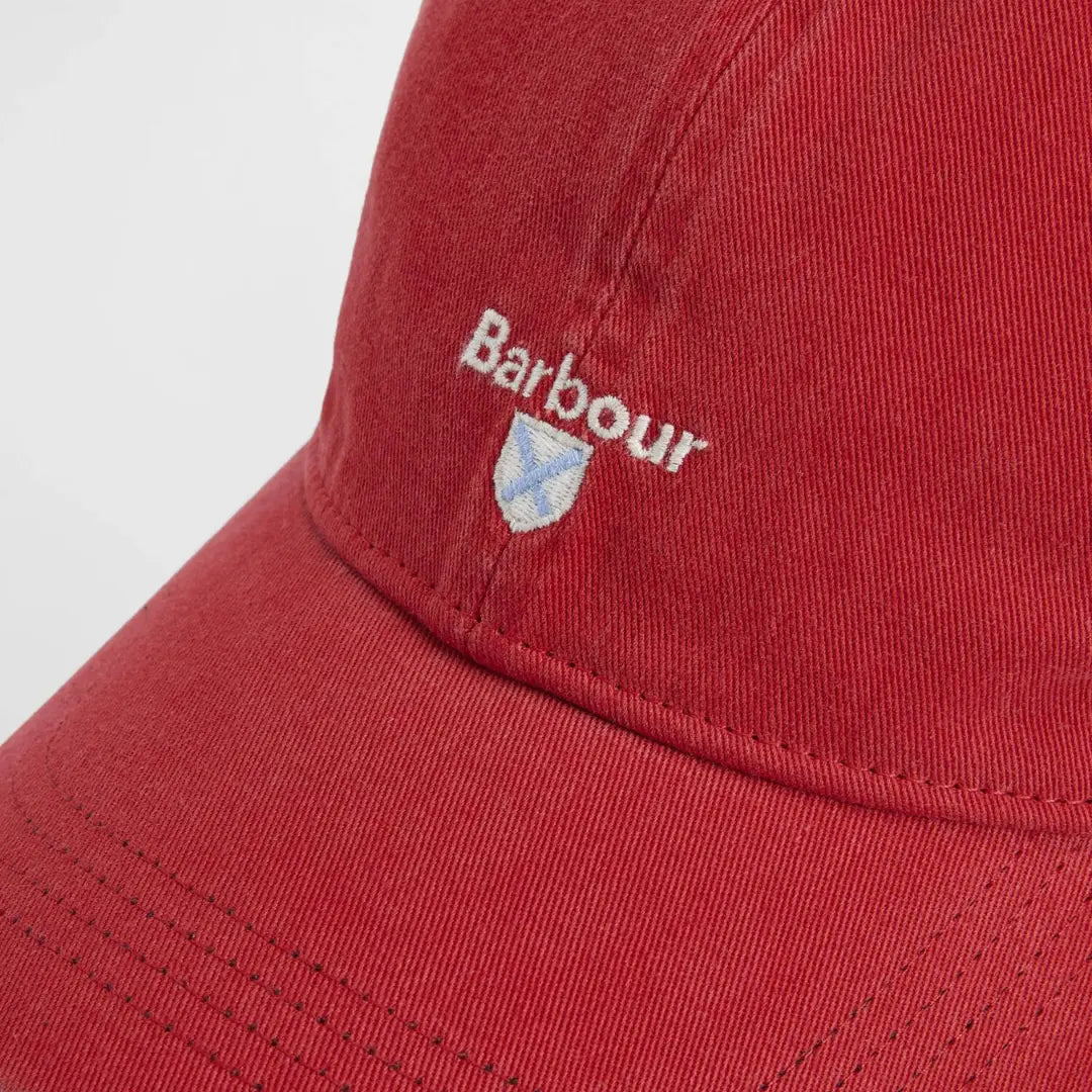 Macro du logo brodé et de l'écusson à croix sur le coton rouge brique délavé