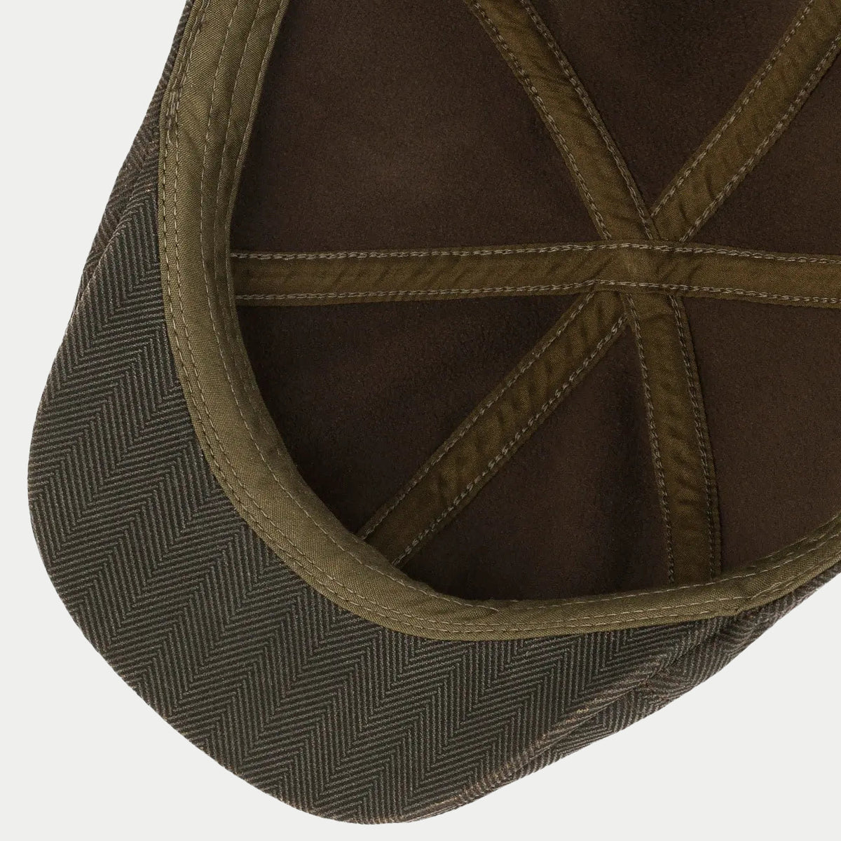 Intérieur de la casquette : doublure brune et biais kaki cousus sur les coutures