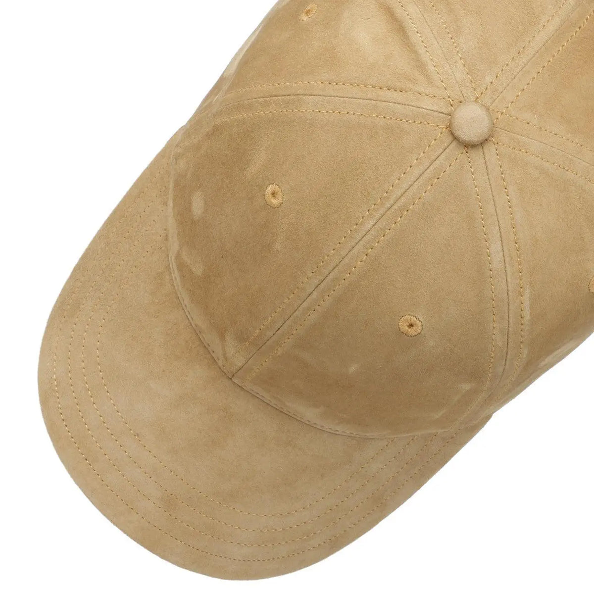 Plongée sur la calotte en cuir beige, œillets brodés et coutures apparentes