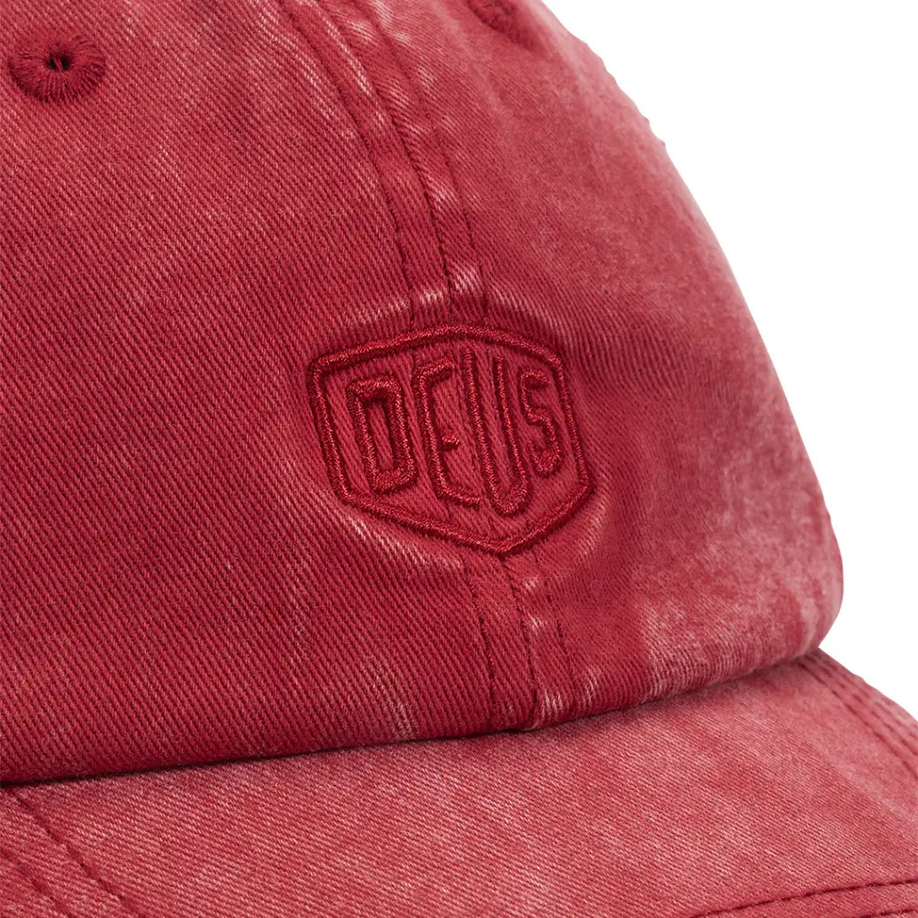 Macro du délavage rouge framboise et du bouclier brodé sur la casquette Garment Dyed Lava Falls